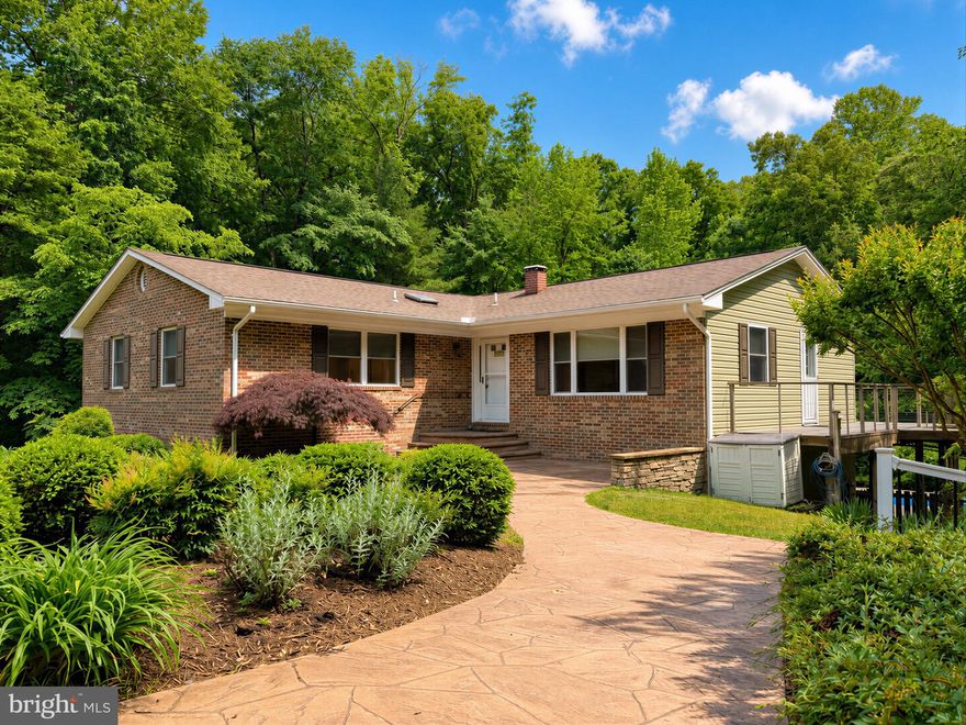 Come home to your own secluded oasis! Tucked into the trees on Gallant Man Dr., this 4-bedroom, 3.5 bath rambler features a saltwater, in-ground pool that's great for beating summer temps, and heated for cooler weather, too! A front addition, solarium and finished basement add up to more than 2,600 sq ft of living space in this freshly-painted, one-level-living home. A nicely landscaped yard leads to the heated front walkway & landing, eliminating the need for winter shoveling and de-icing! A tiled foyer leads past the living room w/ hardwood flooring and into the open kitchen/dining room. The updated kitchen includes Granite counters, Oak cabinets, tile backsplash, and recessed lights. Nice-size dining area leads out to the sun room, overlooking the pool and surrounding woods. Whether you're lounging on the composite wrap-around deck, or poolside, enjoy the serenity that more than two private acres allows. Two big bedrooms, two mid-size bedrooms, one w/ attached bath, and three baths provide plenty of space for everyone. Bath updates include tiled showers, vanities and lighting. A convenient main floor laundry has additional cabinet storage. Downstairs, use the finished bonus room for whatever you need. Fill it with hang-out furniture, game table, big screen TV, hobbies, workshop, fitness equipment... you name it! A sliding door walks out to the fenced pool surround, and the LL half bath is a convenient changing room for swimmers. A lower driveway leads to the side-load LL garage w/ new door, and huge shed. Up top, a second driveway & parking pad access the front entry. The 12x24 shed is capable of storing a small boat and has electric. No HOA, so park your RV or big boat, too! Behind the pool is another acre of woods with partial clearings and flat ground that would make a great location for a woodsy fire circle, archery range, or chicken coop. A new pool liner in '24, gutter guards,  and 5-year HVAC & water heater add comfort and ease-of-care for years to come. It feels like country living, but the Land O' Lakes neighborhood is only a short drive from main commuter routes, shopping/restaurants, and goes to Leonardtown schools. Don't miss a chance at your own private oasis, request your showing today!