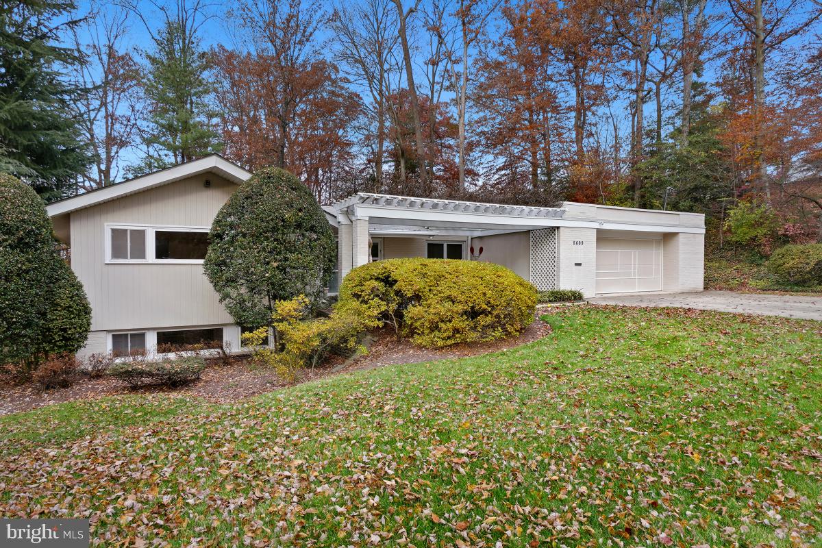 Bright and spacious, this mid-century modern home is sited on a spectacular half-acre lot in sought-after Bradley Park. Introduced by a quintessential pergola and brimming with natural light from its myriad of windows, this verdant oasis boasts an open-concept floor plan, large entertaining spaces, vaulted ceilings, updated kitchen and baths, hardwood floors, numerous skylights and recessed lights and a 2-car garage.. Upon entry, floor-to-ceiling windows across the back of the house showcase the breathtaking lot backing to woods.The main level features a welcoming foyer, a living room with a gas fireplace, a cozy reading/conversation/cocktail area, a large dining room exiting to the deck, an expansive table-space kitchen and a huge mud/laundry room with cabinets and shelves The primary bedroom includes an elegant tray ceiling, a huge walk-in stretched closet, a renovated marble en-suite bath and sliding glass doors to a private balcony, Two additional bedrooms and the redone hall bath complete this level. Downstairs finds the warm family room. The wet bar, refrigerator, and exit to the glorious flagstone patio, make this is the perfect space for casual at-home gatherings. Another bedroom, a home office, a gym/exercise space, a craft room, and extensive storage are also found on this level. Perfectly located just minutes from downtown Bethesda, schools, shopping, and entertainment are nearby. With its close-in location and proximity to major transportation routes and METRO, commuting to Washington, DC, Northern Virginia, and area airports is a breeze.