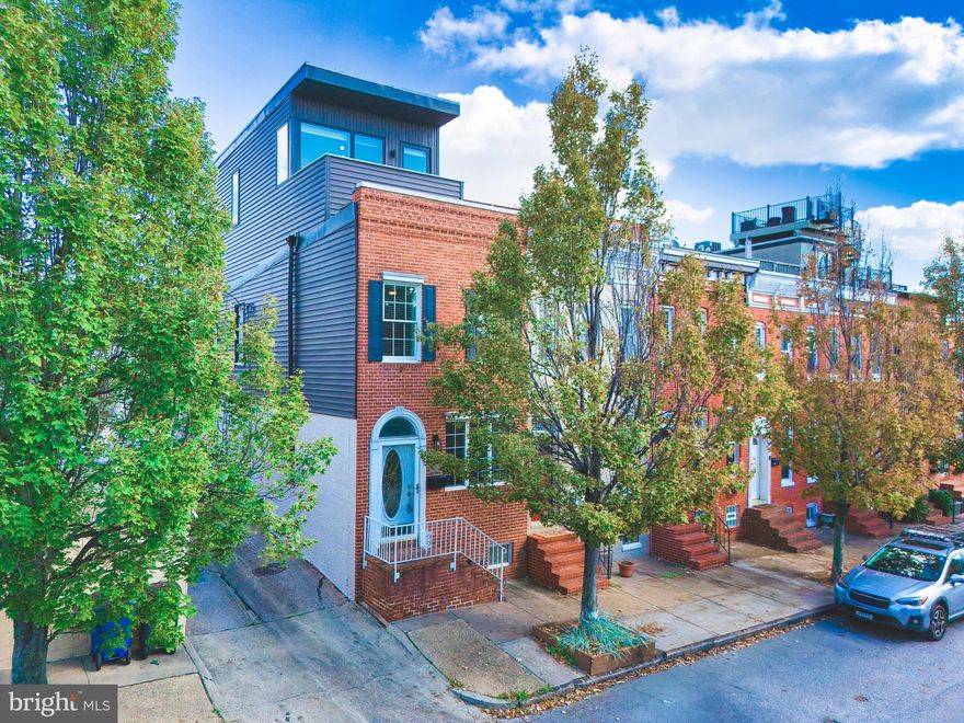 Welcome to 801 S. East Avenue, a beautifully remodeled Canton townhome offering the perfect blend of space, style, and Baltimore charm. This four-bedroom residence includes a fifth/flex room on the third level, currently used as a family room that showcases dramatic panoramic views of the downtown skyline and opens to a private rooftop deck—a perfect place for morning coffee, evening drinks, or small gatherings under the city lights.

The property has been thoughtfully reimagined, including the addition of an entire third floor, creating generous living space while preserving the character that makes Baltimore rowhomes so beloved. Inside, the home balances historic charm with modern finishes, featuring exposed brick, accent lighting, and a contemporary media wall with electric fireplace and custom built-in wood shelving.

Upon entering the main level, you’re greeted by a warm and inviting living room with ample natural light and open flow. A separate dining room connects to a tastefully updated kitchen with modern finishes, plenty of storage, and stainless-steel appliances. Just beyond the kitchen, a mudroom provides a practical transition to the rear of the home where you’ll find a full bathroom and access to an oversized parking pad—large enough to accommodate a full-size SUV, a rare and valuable feature in Canton.

The lower level runs the full length of the home and remains unfinished, offering exceptional storage potential or an opportunity for future expansion.

On the second level, you’ll find three bedrooms, including a bright and spacious front bedroom with tall windows and great natural light. Two additional modestly sized bedrooms and a renovated full bathroom (2023) complete this floor. Hardwood floors span the majority of the home, with carpet in select bedrooms for added comfort.

The third floor is truly a showpiece. It features the expansive primary suite with an updated ensuite bathroom boasting a skylight over the shower that floods the space with natural light. From the bedroom, you can even catch a glimpse of the iconic Natty Boh sign winking from across the city—a uniquely Baltimore view that never gets old. Also on this level is the fifth/flex room, currently used as a family room, offering sweeping skyline views and direct access to the rooftop deck. Whether you envision it as a media room, home office, guest space, or lounge, this level delivers flexibility and luxury.

Additional highlights include attic storage accessible from the upper level and a sump pump with French drain system for peace of mind.

Major updates and improvements:
    •    Roof – 2023
    •    Dual-zone HVAC: new electric heat pump & central air (third floor, 2023); new gas furnace & central air (first & second floors, 2021)
    •    Hot-water heater – 2019
    •    Bosch dishwasher – 2020
    •    Dimplex electric water vapor fireplace – 2019
    •    Carpet – 2023
    •    All-new second-floor bathroom – 2023
    •    Updated lighting and ceiling fans throughout

With three full bathrooms, four true bedrooms, and the flexibility of a fifth room or upper-level family space, this home offers rare versatility for the neighborhood. Every detail—from the thoughtful updates to the efficient systems—has been designed for comfort and convenience.

Located just steps from Canton Square, the waterfront, restaurants, coffee shops, and the best of city living, 801 S. East Avenue delivers the lifestyle you’ve been waiting for. Move right in and enjoy modern living with classic Baltimore character—a perfect combination in one of the city’s most sought-after neighborhoods.