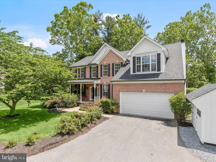 Welcome to this stunning, private colonial, centrally located in the highly sought-after Ellicott City area of Howard County! Set on a beautifully landscaped lot, the brick and vinyl siding exterior is enhanced by a charming front porch and an expansive backyard retreat featuring a two-tiered covered composite deck, a brick patio, and a built-in outdoor fireplace, perfect for year-round entertaining. Step into the elegant two-story foyer and discover a traditional floor plan with thoughtful upgrades. Gleaming hardwood floors lead you to a private office with French doors, double crown molding, chair railing, and box wainscoting. The formal living room features tile flooring and continues the sophisticated trim detail, flowing seamlessly into the dining room with a tray ceiling, dentil crown molding, chair railing, and box wainscoting. The open-concept kitchen is a chef’s dream with 42” cabinetry, stainless steel appliances, granite countertops, decorative backsplash, and a two-tiered island with a breakfast bar. A sunny breakfast area leads into the spacious family room, highlighted by plush carpet, soaring ceilings, and a cozy wood-burning fireplace. Upstairs, the luxurious primary suite is your private retreat, boasting a vaulted ceiling, gas fireplace, hand-scraped luxury laminate flooring, a sitting area, three walk-in closets, and a spa-inspired en-suite bath with a double vanity, jetted soaking tub, and walk-in shower. Four additional bedrooms, some with new carpet, walk-in closets, and others with updated laminate flooring and a well-appointed hall bath, complete the upper level. The fully finished lower level offers flexible living options, including two potential bedrooms, a full bath, a large recreation room with a gas-burning fireplace and modern flooring, and direct walk-out access to the backyard. A spacious storage and utility room adds convenience. Recent updates include, new roof (within the last 2 years) , both air conditioners updated less than 5 years ago, water heater (about 5 years old), new carpet upstairs, new flooring in closets and lower level, freshly painted interiors, and updated stairs and decking on the exterior. Located near major commuter routes including US-40, US-29, and I-70, with easy access to Columbia Mall, Merriweather Post Pavilion, downtown Baltimore, and Washington D.C., this exceptional home offers comfort, style, and convenience all in one!