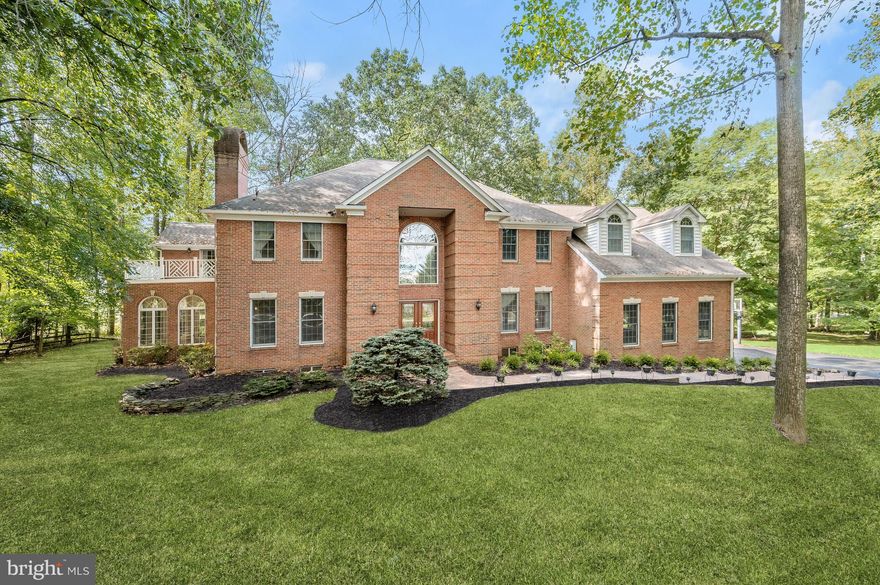 Elegance awaits in this absolutely stunning custom-built brick Colonial home on over three acres tucked away in the sought-after Twelve Hills neighborhood in Clarksville, surrounded by mature trees. Sense of arrival begins as you step into the grand two-story foyer highlighted by a marble floor, graceful columns, two coat closets and a stately curved staircase. Adorned with ornate accent millwork, recessed lighting, sun-drenched windows and exquisite details throughout, this entertainer’s delight is the perfect oasis with the peaceful setting you have always dreamed of! The formal dining room offers a timeless design with its sophisticated tray ceiling, box wainscoting and space for any size gathering. A cozy wood-burning fireplace graces the formal living room with ultraviolet protection on the windows and French doors lead to the light-filled sunroom with Palladian windows overlooking the woods and sliding glass doors to the brick patio. Let your senses come alive in the chef’s kitchen that is fully equipped with ample counter space, a two-tiered island with an electric cooktop and breakfast bar, a walk-in pantry, a breakfast nook for casual meals and brand new luxury vinyl plank flooring. Enjoy festive celebrations in the breathtaking family room with a coffered ceiling, impressive picture windows and a double-sided wood-burning fireplace shared with the adjacent office that is ideal for working at home with privacy. Just past the kitchen, a bedroom suite with an attached bathroom is perfect for those looking for a space on the main level for overnight guests. The mudroom offers additional storage and access to the expansive deck. Ascend to the upper level to relax in the tranquility of the primary bedroom suite that features plush carpet, a wood-burning fireplace, a cathedral ceiling, private balcony, two walk-in closets and a sitting room with a wet-bar that is great for a morning coffee station. Unwind in the luxurious bathroom accented by a soaking tub, a glass-enclosed walk-in shower, a soaring vaulted ceiling with skylight, a linen closet, a separate water closet with bidet and a massive vanity with dual sinks. The second bedroom suite features a private bathroom, a walk-in closet and stairs up to the loft that is a perfect space for a play area with access to the attic for additional storage. The third bedroom also has a walk-in closet and down the hall, the large laundry room is conveniently located on the bedroom level. Completing the upper level, the expansive fourth bedroom suite has an adjacent sitting room that could be used as an additional bedroom, office or lounge space with access to the third full bathroom that showcases a soaking tub and walk-in shower. Downstairs, the fully-finished lower level recreation room is the perfect area to watch the big game or view your favorite movies with space for everyone’s activities. A bonus room with a walk-in closet would make an ideal home gym, hobby room or potential sixth bedroom with a full bathroom around the corner. A cedar closet and endless storage complete the lower level. The oversized three car garage with an electric vehicle charging station and additional storage space allows for easy access to the home where placing seasonal tools and equipment is a breeze. As your day comes to a close, enjoy the peaceful sights and sounds of nature that surround you outside on the rear Trex deck or brick patio. All of the closets have custom organization systems. Electric dog fence and a whole-house surge protector. Recent updates include a refreshed kitchen including new LVP flooring and painted cabinets, high-efficiency water heater in 2019, an 81 gallon pressure tank for the private well replaced in 2021 and a 30 year shingle roof in 2009 with new skylights. Energy-efficient four zoned electric heating and cooling systems with two back-up oil furnaces. Excellent location and top-ranked Howard County Schools! Owner financing may be available.
