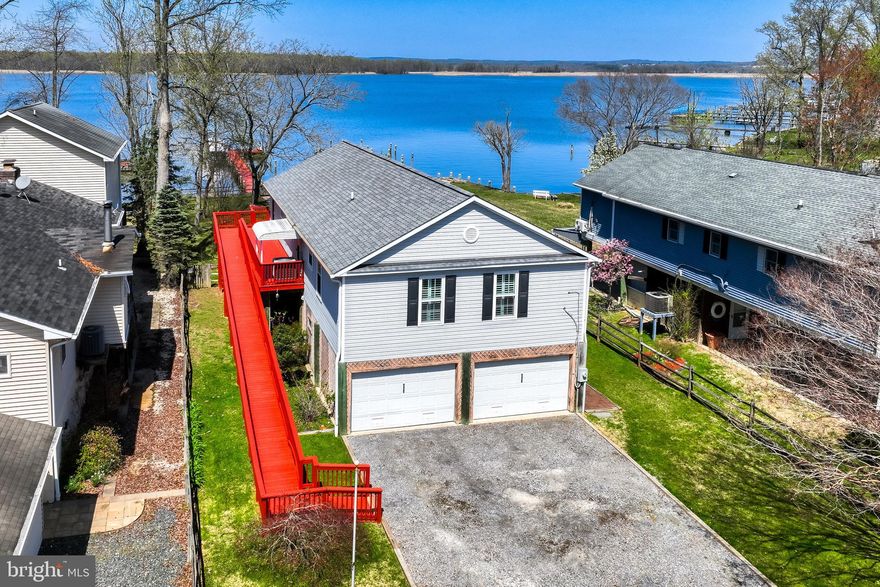 Charming Waterfront Home in Harewood Park. Experience breathtaking waterfront living with gorgeous shoreline, private dock, pier, and boat slips with lift in the heart of Harewood Park. This 3 bedroom, 2 ½ bath waterfront retreat offers stunning water views and unforgettable sunsets from multiple rooms, delivering the perfect blend of charm, comfort, and true coastal lifestyle. Step inside to a welcoming foyer that opens to a bright, open layout featuring hardwood flooring, crown molding, recessed lighting, and walls of windows showcasing panoramic water views. The living and dining areas flow seamlessly, creating an ideal space for entertaining or relaxing while enjoying the serene waterfront backdrop. The sun-filled family/sunroom is a true highlight, featuring a cozy pellet stove and expansive windows framing sweeping water views. With sliding glass doors on both sides leading to outdoor decks, this space is perfect for seamless indoor-outdoor living, year-round entertaining, or simply unwinding while overlooking the water. The kitchen offers abundant counter space, white cabinetry, pantry storage, and a convenient laundry area designed for everyday ease. Newer windows throughout the home, paired with plantation shutters, add style, comfort, and energy efficiency. The primary suite includes generous closet space with custom shelving and a beautifully updated en-suite bath with a walk-in shower. Two additional bedrooms feature hardwood flooring and share a fully renovated hall bath with modern finishes, a custom-tiled shower, and designer details. The expansive lower level provides exceptional flexibility for a recreation room, workshop, garage, or storage for kayaks, paddleboards, and all your waterfront gear, plus a convenient half bath. Outdoor living shines with a screened porch overlooking the water, perfect for dining, entertaining, or relaxing in every season. The home offers dual access to the main level with ramp and stair entry, along with a large fully fenced yard ideal for gatherings, pets, and outdoor enjoyment. Enjoy private waterfront living with a well-maintained bulkhead, pier, and boat slip with lift, perfect for boating, fishing, kayaking, or simply soaking in the peaceful setting. Additional highlights include Ring motion-activated floodlights and a security system for added peace of mind, along with thoughtful updates throughout. Tucked on a quiet, no-through-traffic street, this property delivers privacy, beauty, and the ultimate waterfront lifestyle while every day feels like a getaway. Come take a tour and make 6928 N River your new Waterfront Home Sweet Home!!!