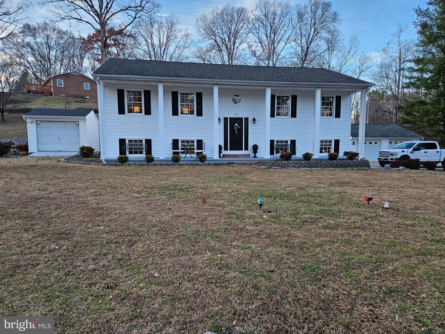 50X5 covered front porch with concrete floor. No HOA. Deep well, shed, detached 25X22 garage with electric entry lock and openers, 16 x 15 covered rear deck with metal roof, onsite septic. Dog kennel conveys, one chicken coop conveys, smaller chicken coop does not convey. NO carpeted floors for those with allergies. All floors have been upgraded on both levels. Quartz counter tops and back splash in kitchen. Upgraded: sinks. baths, kitchen, appliances, cabinets. Shed with overhead door. Extensive landscaping, dental and chair rail molding with 5 1/4 inch baseboard molding in office and FR. Double sink, walk in shower, ceramic tile flooring and new toilet in main BR bath on lower level. 65" wall mounted TV in FR and 60" wall mounted TV in LR conveys. New closet organizers in main BR closet on lower level. Entire interior freshly painted.
