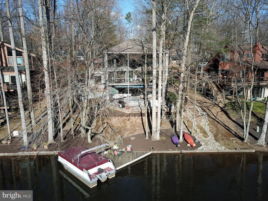 Welcome home to amazing waterfront living on Reston's Lake Thoreau!  Enjoy waterfront views from every level of this awesome, contemporary home.  The front breezeway, overlooking a beautiful, private stone courtyard below, welcomes you to the main level with sweeping views of the lake.  The living room offers amazing lake views and sliding glass doors lead to a spacious, yet private, covered deck with a spiral staircase to the lower level deck.  The living room has a gas fireplace and opens to the kitchen and dining room.  The dining room also has access to the main level deck through sliding glass doors.  Great space to entertain, and great "flow" between the indoor and outdoor spaces!  The kitchen is open and bright and has an island with dining space and great natural light and views of the lake.  The kitchen also features hardwood floors, granite counters and stainless steel appliances.  The primary suite is located on the top level of the home with its amazing floor-to-ceiling waterfront views!  The primary suite has new carpet, a walk-in closet and a primary bathroom with granite, double vanity sinks, and a bright and light tiled shower.  Bedroom #2 has been opened up from the original floor plan to offer an office/desk space and large, double-door closet.  There is also a beautiful full bathroom on this level, as well as a sitting room with hardwood floors and a "chalkboard wall" and a light and bright laundry room.  One level down from the main living level is a family room with new hardwood floors, a wood-burning fireplace and sliding glass doors leading to a large, brick patio - great for entertaining - with steps to the lower level deck and steps to the private dock and shoreline.  There is also a third bedroom with new hardwood flooring, as well as the third full bathroom with a shower/tub.  On the ground level, enjoy a spacious recreation room!  This is great space for a movie room, workout room, lower level office, etc. The fourth bedroom is also on this level, complete with a large closet and waterfront views!  There is also an unfinished storage room...great for a small workshop and extra boat equipment storage and seasonal storage.  Updates: The roof was replaced in 2010 (40-year roof). New dishwasher (2021). New dryer (2020). New hardwood floors in the family room and bedroom #3 (2021).  New carpet in the primary bedroom and stairway (2021).  The entire exterior was painted (2018).  The living room, stairway, kitchen, two bathrooms, recreation room, sitting room, one bedroom, laundry room and the loft were freshly painted (2021).  This home is beautifully situated on the lake, with terrific views throughout the seasons.  Enjoy the convenience to all of Reston's amenities including pools, tennis courts and miles of trails.  What about commuting? It's less than a mile to the Wiehle Avenue Silver Line Metro.  This is such a great location! Enjoy waterfront living and the ease and convenience to the Metro, major commuter routes and awesome dining and amenities!  Why not vacation 24/7?! Schedule your tour today!