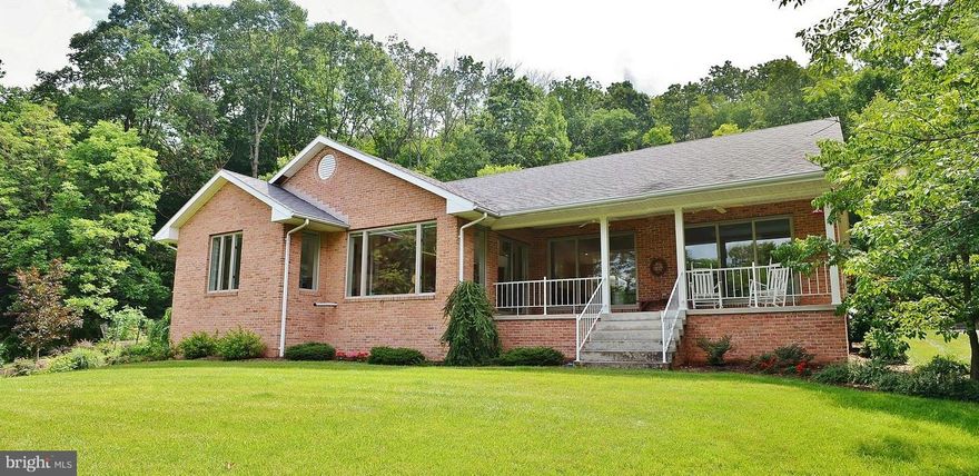 In town location w/ a country feel.  End of the street location, surrounded by trees for privacy. Access to the spacious covered front porch from the Sun Room, LR, or MBR.  One level living w/ gleaming hardwood floors, Saltillo tile, built ins + full unf. bsmt. City water & sewer+well for outdoor water use. Enjoy the peaceful trickling waters feeding the beautiful Koi Pond. Paved DW + 2 car garage