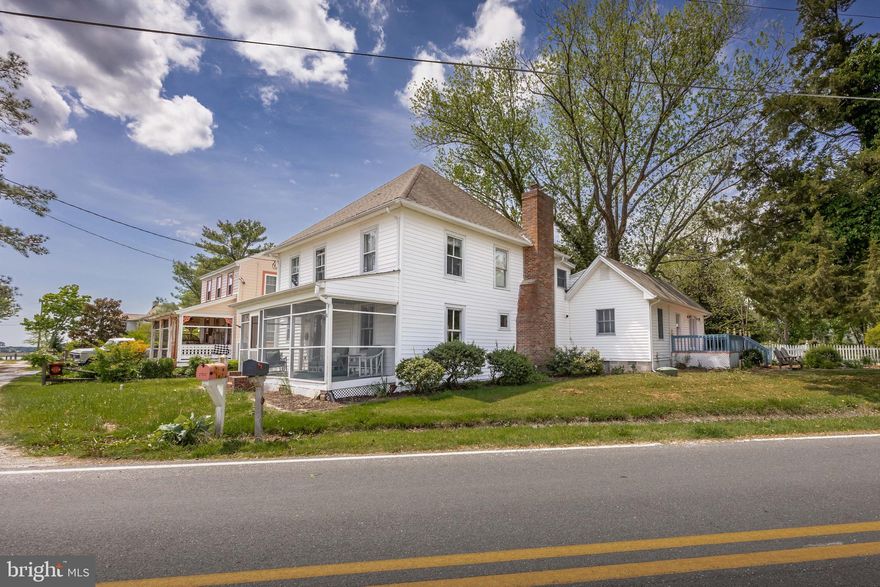 Welcome to this beautifully preserved and thoughtfully updated historic home located in the heart of the quaint, waterfront village of Whitehaven, Maryland. Just steps from the Wicomico River and the iconic Whitehaven Ferry, and Whitehaven Hotel, this 3-bedroom, 2-bathroom home offers over 2,300 square feet of timeless charm and modern luxury.

Step through the original front door, adorned with stained glass, into a welcoming foyer that leads to the dining room. Just beyond, you’ll find a cozy living room featuring hardwood floors and a wood-burning fireplace. A chef’s dream, the remodeled kitchen boasts a commercial-grade Viking range, custom range hood, and elegant finishes. Enjoy peaceful views down the stone road toward the Wicomico River from the charming front screened-in porch

The first-floor owner’s suite is a private sanctuary with its own spacious living area, plenty of storage, large bathroom, and a private deck overlooking the peaceful marsh. With its own exterior entrance, this space can easily be converted into an in-law suite or guest quarters.

Upstairs, you’ll find two more beautifully appointed, nautical-themed bedrooms, a large bathroom, and charming details like a built-in daybed nook surrounded by windows—perfect for relaxing with a good book. Throughout the home, original hardwood flooring ties the spaces together with warmth and character.

Additional highlights include a spacious mudroom with storage leading to a lovely brick patio, a huge detached two-car garage, central HVAC, and a lush, expansive yard that includes an additional lot—offering just under half an acre of space to enjoy.

This home comes fully furnished and has operated successfully as a vacation rental, making it an ideal investment opportunity or personal escape.

Don’t miss this rare opportunity to own a piece of Maryland’s Eastern Shore history!