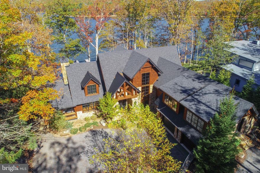 This stunning lakefront residence is a true masterpiece on the shores of Deep Creek Lake — where design, nature, and craftsmanship converge. Completely reimagined and luxuriously curated with Restoration Hardware furnishings, fixtures, and décor throughout, it offers a seamless blend of modern sophistication and timeless mountain warmth.
With unobstructed, year-round views of Deep Creek Lake and the surrounding mountains, the scenery is nothing short of breathtaking. The home’s expansive wall of glass brings the lake to your doorstep, with nearly every room offering a front-row view of the water’s edge.
The open main-level layout provides effortless living, featuring a gourmet kitchen, four stunning stone fireplaces, vaulted ceilings, and an enclosed screened porch perfect for year-round enjoyment. Each bedroom offers the privacy of an en suite bath, and every detail reflects a commitment to quality and style.
From its storybook architecture to its elevated finishes, this home is more than a lake retreat — it’s a statement of elegance and connection to nature. Quite simply, one of the most exceptional properties ever offered at Deep Creek Lake.