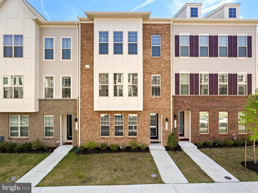 Stunning 4-Level Luxury Brick Townhome with Rooftop Deck in East Quarter!  This 3-year-old, 4 bedroom, 2 full/2 half-bath home is filled with designer upgrades and thoughtful details. The entry level offers a spacious living area, powder room, storage, and an oversized 2-car garage. The main level impresses with an open floor plan featuring a gorgeous chef’s kitchen with 42" shaker cabinets, quartz counters, massive island, premium stainless appliances, and a four-burner cooktop. The great room boasts a mosaic gas fireplace and built-ins, while a covered deck overlooks a park-like setting. Upstairs, the primary suite includes a luxury bath with dual vanities and a frameless shower; two additional bedrooms share a full hall bath. The top-level opens to another spectacular living space or bedroom complete with rooftop deck—perfect for entertaining! Enjoy 9’ ceilings, hardwood stairs, upgraded lighting, and more. Walkable to restaurants, Starbucks, shopping and more.  Conveniently located near major commuter routes and Downtown Leesburg’s shops, dining, and wineries!