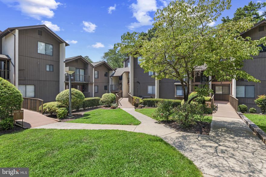 Waterfront condo in Canal Woods on the second floor offering 3 bedrooms, all with water views, and 2 full bathrooms. The kitchen has quartz counters while the primary bathroom has an updated walk-in shower, new vanity, and toilet. The dining room offers chair railing and opens to the living room  with sliding glass doors that lead to a waterfront balcony. The first bedroom has built-ins and a window seat with views of the pond. Water and sewer are included in the condo fee.