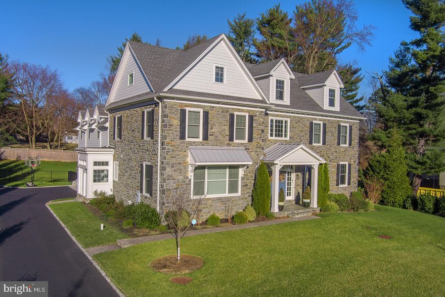Welcome to 719 Conshohocken State Road, an exquisite Main Line colonial home that redefines luxury living. Nestled on a flat, 0.70-acre lot, this stately residence boasts six bedrooms, six full bathrooms, 1 powder room, and a generous 6,735 square feet of living space. Built just seven years ago, this stone-clad colonial masterpiece offers a perfect blend of timeless charm and contemporary elegance.
As you approach, be greeted by the double doors that open to a 2-story, light-filled foyer. A dramatic double staircase and a striking modern chandelier set the tone for the grandeur that awaits. The center hall seamlessly integrates the interior with the private backyard oasis, creating a sense of expansiveness and connection to nature.
The living spaces, adorned with subtle gray and white tones, feature generous-sized windows, gorgeous hardwood floors and French doors that invite natural light and provide views of the lush grounds. The formal living room and dining room showcase elegant yet contemporary architecture, boasting coffered ceilings, custom millwork, and large windows overlooking the front yard.
The heart of this home lies in the gracious family room, complete with a double fireplace, porcelain tile surround, custom built-ins, and French doors leading to the paver slate patio. Flowing effortlessly into the chef's kitchen, this space is designed for both functionality and style. The kitchen is a culinary dream with quartz countertops and a large quartz waterfall island, white shake style cabinets, a Thermador appliance package, chrome fixtures, breakfast nook and wonderful wet bar.  Completing the first floor is the convenient mudroom with access to the driveway, a three-car garage, and a powder room. 
Ascend the stairs to the second story, where a loft-like landing with built-in bookshelves and window seat, opens to five bedrooms, all with hardwood floors, large closets and airy interiors.  The Primary suite is a sanctuary of luxury, featuring vaulted ceilings, a sitting area, two sizeable walk-in closets, and a spa-like en-suite with a glass-enclosed shower, soaking tub, double vanity, and water closet. Four spacious bedrooms, one with an en-suite, a Jack and Jill bath, a full hall bathroom, and a large laundry room with built-in cabinets and sink finish this level.
The third floor presents a large, open second family/play room and a full bathroom. The lower level is an entertainer's paradise with numerous possibilities, including a recreation room, theater room, wine closet, fitness studio, a nanny suite with a full bathroom, a storage room, and direct access to the backyard.
Step into the ultimate outdoor retreat on the slate patio with a gas fireplace, surrounded by lush grounds and a sense of privacy and seclusion. This home is not just a residence; it's a triumph of style and sophistication that embodies the elegance and prestige for which the Main Line is renowned.
Conveniently located just minutes away from Center City Philadelphia, this home offers easy access to restaurants, shopping, parks, walking trails, and more. All of this is complemented by the distinction of being situated in the award-winning Lower Merion School District.
Experience the epitome of luxury living at 719 Conshohocken State Road – a home where every detail has been meticulously crafted to provide a lifestyle of unparalleled comfort and sophistication. Schedule your private tour today and step into a world of timeless elegance.