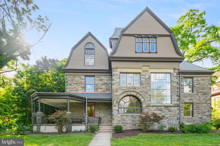 Welcome to the Jesse A Tilge House, a one-of-a-kind and truly stunning home in the Pelham district of West Mount Airy. Designed by renowned Philadelphia architect George T Pearson, this exquisitely detailed and elegant property features striking craftsmanship and has been meticulously restored to preserve its historic heritage and provide every modern amenity. The 6-bedroom, 6-bath house is set high up off the street and sits on almost an acre. Enter through the dramatic Dutch door to a grand foyer with exquisite millwork, soaring ceilings, and fireplace. To the left is a charming living room with leaded glass windows that connects to a formal dining room with built-in buffets and fireplace. At the center of this distinguished home is a state-of-the-art kitchen with brand new custom cabinetry, high end appliances, and a spacious 10’ stone island that complement the coffered ceiling, wood-paneled walls, and large stained-glass window. The butler’s pantry has been modernized with floor to ceiling custom pantries and wet bar. Also on the first floor are mud room, laundry room, powder room, and an abundance of storage space. An enclosed sunroom leads out to the large rear yard, wrap around vaulted porch, and newly paved driveway for 3+ cars. Ascend the magnificent central staircase, awash in the soft light that filters through a massive stained-glass window. On the 2nd floor is a grand primary suite with large dressing room featuring wall length custom closets and fireplace. The luxurious light-filled primary bathroom offers classic elegance with a custom shower, restored clawfoot tub, and large linen closet. Two additional bedrooms on the second floor, accessible by a secondary staircase, have large closets and fireplaces and bathroom. On the third floor are three bedrooms, two full bathrooms, one half bathroom as well as an expansive family room with kitchenette. The multi-light and leaded glass windows have been painstakingly restored. This magnificent home, historically designated in 2022, features upgrades and amenities including central air, updated electrical and plumbing, designer lighting, and refinished hardwood floors throughout. Restored from top to bottom, this house is conveniently located close to the Upsal St. train station and with easy access to the shops and dining in Mount Airy, Chestnut Hill, and downtown Philadelphia. This captivating home will take your breath away!  Extensive improvements list is available upon request.