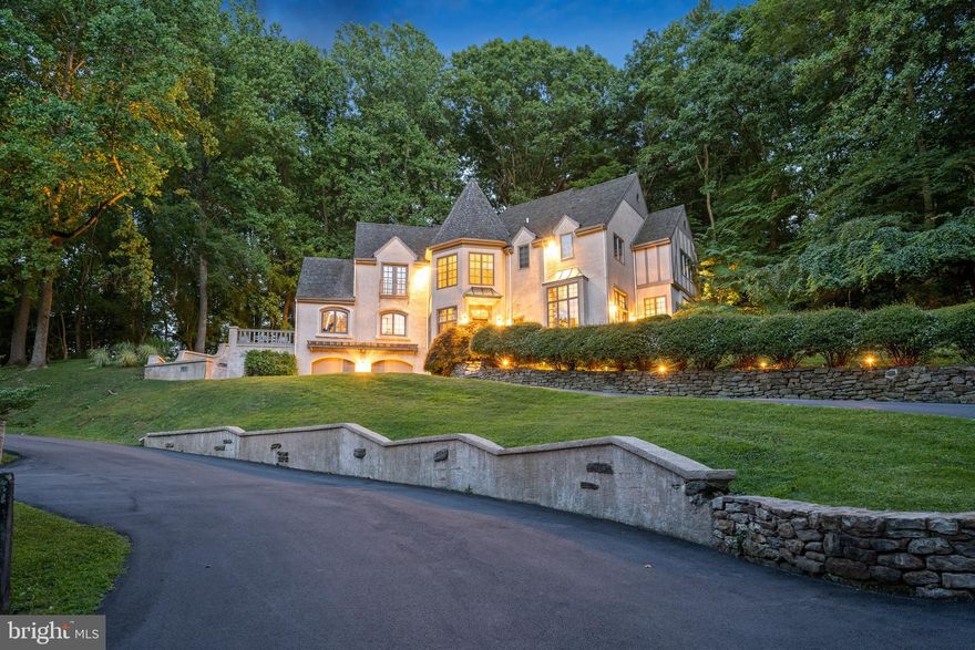 This truly exceptional Modern French Normandy  home is in pristine condition blends an open, modern floor plan with classic charm and quality craftsmanship. Beautifully maintained rich hardwood floors are found throughout. It is wonderfully positioned in a scenic, quiet setting in a family friendly cul de sac surrounded by natural beauty. 
The flagstone entry hall provides a gracious introduction and warmly welcomes you home. The living room features a marble gas fireplace and overlooks the two-story wood paneled library accented with decorative moldings. A spacious and bright dining room located adjacent to the kitchen has great flow for entertaining. Highlighted by a beautiful center island with counter seating and top-quality appliances, the kitchen is both beautiful and functional, while the breakfast area overlooks the grounds and provides outside access to one of two decks. The kitchen opens to an expansive family room which has a soaring ceiling and a palladium window that provides breathtaking views of the grounds. A fireplace with stone surround brings warmth to the space and features a wet bar area ideal for entertaining. A black granite powder room off the foyer completes the main floor. A curved stairway offers an airy connection between each level and ascends to the second floor. The spacious primary suite has a high tray ceiling and two large walk-in closets. The updated primary bathroom comprises a double vanity, an Italian marble steam shower, an inviting Bain ultra-Jacuzzi tub with chromotherapy feature, and a skylight that brightens the space with natural light. Three additional bedrooms are generously sized and include abundant closet space. One includes its own updated private bathroom; the other two bedrooms are connected by a shared updated bathroom. A few steps down from the main floor is the finished lower level which features a recreation/playroom area and an additional bedroom suite/office space with an attached full bathroom. This level provides access to the oversized 2-car garage. The home's convenient location is in close proximity to all major transportation routes, Center City Philadelphia, restaurants, shops, entertainment, and award-winning Lower Merion Township schools.