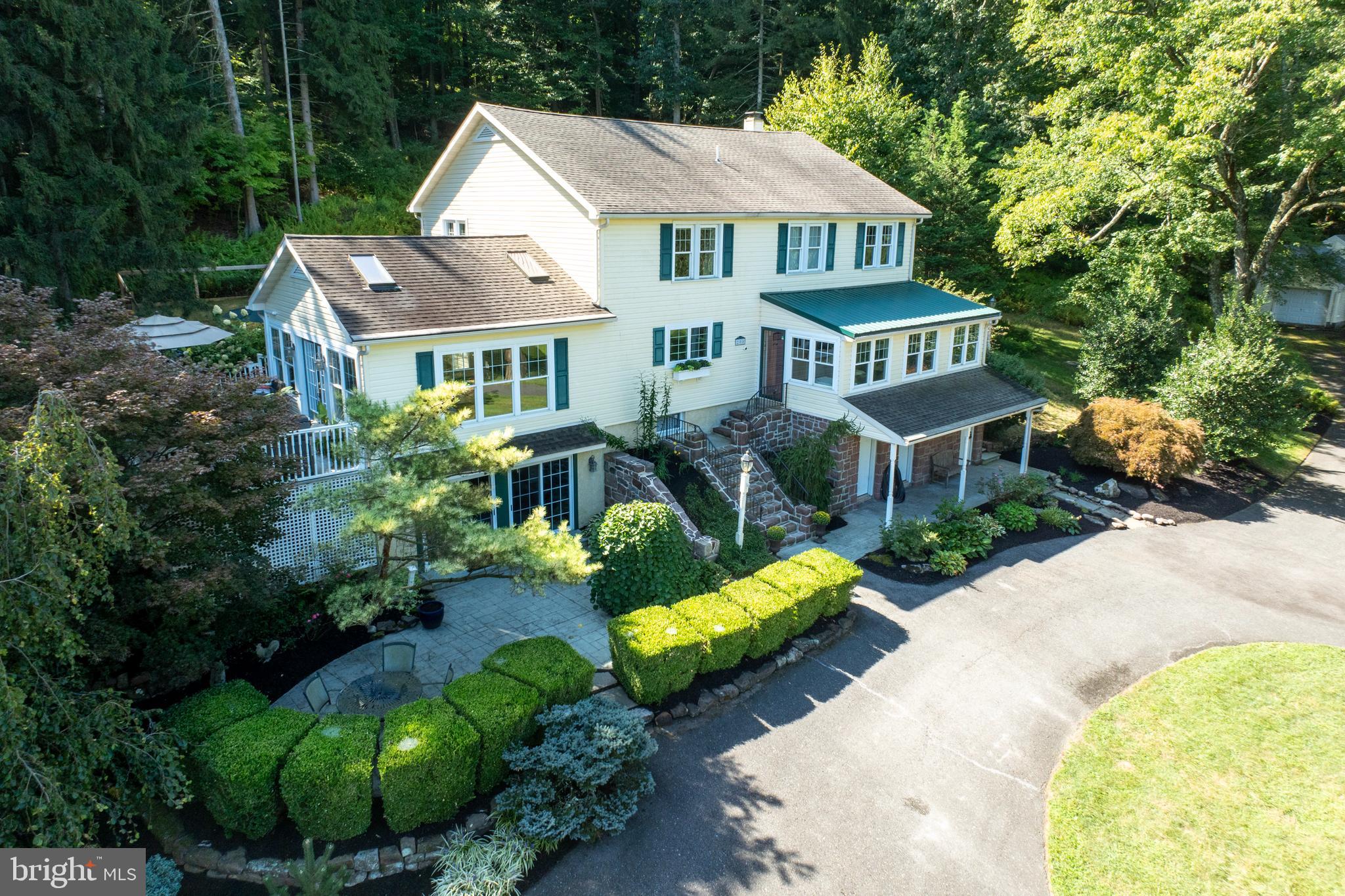 Nestled on 18 sprawling acres, this exceptional property offers seclusion and serenity, with not one, but two beautiful homes, an oversized 5-car garage, & a great workshop! A private tree-lined drive over a quaint stone bridge takes you to this spectacular property. MAIN HOUSE Highlights: Walk up to an enclosed porch w/ tile floor, vaulted ceiling, & surrounded by windows, The Main door opens into a warm welcoming home. The dining room exudes a rustic elegance w/ birch hardwood floors that flow throughout much of the house, this room is accentuated by striking stone pillars, creating a perfect balance between a modern design & natural elements that you will see throughout the house. Stylish pendant lights & large double windows w/ antique glass enhance the atmosphere. The dining room is open to a beautiful office area, thoughtfully designed to be tucked away yet connected to the rest of the house, w/ corner windows for natural light, built-in shelving, & a private entrance. The powder room is lovely w/ Venetian plaster, a custom vanity w/ a copper sink, & hardwood floors. The kitchen is the heart of the home designed for both culinary enthusiasts & those who love to entertain. The centerpiece of this space is a massive island 10'3" x 4'3" w/ a prep sink, perfect for meal prep or casual dining w/ 4 bar stools & lighted w/ 3 pendant lights. Classic white 61-handle kitchen cabinets w/ many cabinet pull-out features including spice, tray, & trash. 2 large pantries (plus the walk-in pantry in the next room) give you an abundant amount of storage space. Equipped w/ stainless appliances including a Jenn-Air 48" refrigerator/freezer, 48" pro range, dual fuel, & dual ovens w/ a 6 gas burner & griddle range. oven vent, trash compactor, Fisher-Paykel 2-drawer dishwasher, & drawer microwave. Complementing the high-end appliances are the elegant & durable soapstone countertops. The stainless farmhouse sink is 10" deep & 33 W x 19 L. Tile backslash. When hosting, your guests can relax by the fire & still be connected to the kitchen's lively atmosphere, this stunning stone fireplace area can be a sitting area as it is now or a great place for a table depending on how you like to entertain & live. The living room is warm & inviting. Featuring rich original hardwood floors, & a stunning wood cathedral ceiling w/ open beams. Natural light floods through the surrounding windows and French doors that open up to the large surrounding deck & patios, blending indoor & outdoor living seamlessly. A built-in window seat offers a cozy place to enjoy the view. Barn doors can separate the living room from the kitchen if desired. Let's go upstairs! The primary bedroom is a true retreat spanning an impressive 31 x 15 ft, offering ample space for relaxation & comfort. 12 x 8 lux walk-in closet offers generous storage for all your wardrobe needs but if not, there is a second closet as well. The ensuite bathroom is designed w/ thoughtful details to elevate your daily routine, features include a walk-in shower surrounded by creative tile work, luxurious rain shower & a wall-mounted shower w/ independent water lines, 2 bench shelves & an inset shelf for toiletries & essentials. The ensuite boasts two vanities, each w/ a sink, one includes a dedicated makeup table. Tile floor & a linen closet. Laundry is right outside your door, easy access for everyone to use. 2nd bedroom has a walk-in closet and a crystal chandelier, & an additional 3rd bedroom on this floor. Hall bath w/ large vanity & a granite countertop, tub w/ surround & tile floor. The basement has a lot of finished space including a great bar and game room that is an easy walk down the steps from the living room, this vibrant space includes a wet bar, built-in lighted shelves & bar, mini split & sliders to lower patio. Craft room, storage rooms, utility room & powder room. 2ND HOUSE is delightfully decorated & has 2 bedrooms,a full bath & basement. Workshop has garage space, & work space. Come tour!