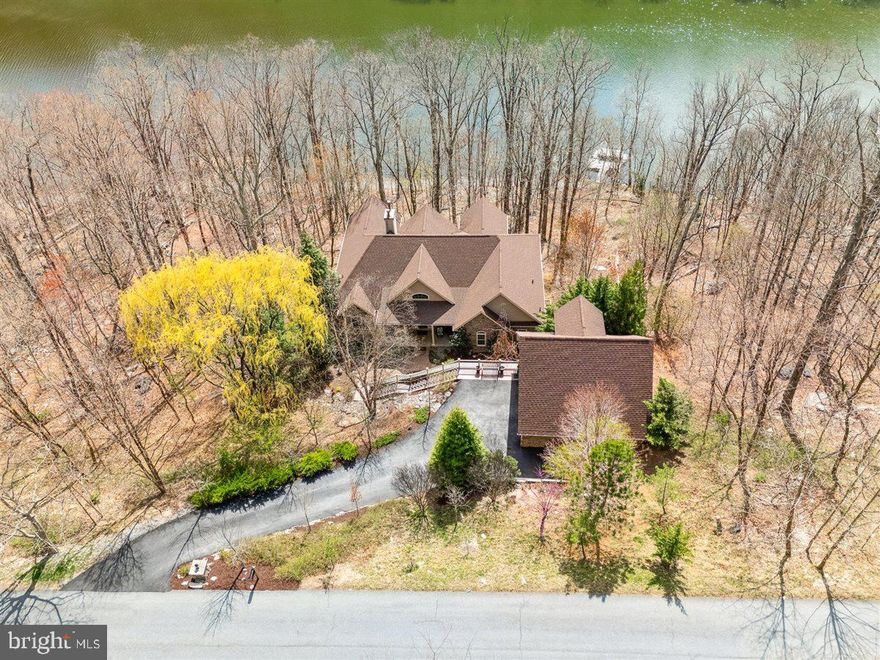 Welcome to LAKEFRONT living at its finest!  This stunning home with only one owner so far is available to purchase for the first time in years; and every detail shines!  The care and attention given to the layout and livability is evident!  Step inside the home from the cosy and private porch and take in the large palladian windows with stunning lake views from the great room!  The stacked stone double height fireplace offers a cozy space with ample room to host family and friends. This central great room divides the main level living into an owner's oasis and on the other side is an entertainment space with luxury and charm!  Step out of the great room and enjoy the expansive deck on this level with stunning views!  The kitchen is spacious and includes a huge island, eat-in space, the knotty alder cabinets are to be admired for their warmth and functionality!  The cream counters offer a beautiful contrast to the cabinets and the tiled flooring. The dining room takes centerstage with stunning views of the lake from two sides; dine with a view!  Off the kitchen is a deck where you can step outside and enjoy yet another aspect of the lake views.  Another entrance is located next to the eat-in kitchen and features a mudroom in grand style.  Spacious and so functional one of the TWO laundries in this home!  Take off your boots, and hang your coats; this mudroom has room for it all!  The owners suite is a joy to experience. With stunning windows from the bedroom and views of the lake and the trees it is an oasis of calm. This bedroom has access directly to the deck as well as the dining room; enjoy all that nature has to offer.Two large closets offer ample space!  The spa bathroom with neutral colours and ceramic tiles with a large soaking tub and separate shower have views of the landscaping through beautiful arched windows.  The main floor also offers an office (easy to convert to a fourth bedroom if you wish) with beautiful views of plantings and a powder room for your convenience.  Step down to the lower level and you will find a large den complete with wet bar and views with a deck running the length of the back of the home!  Open the doors and experience privacy and lake access. On one side is a guest suite or second owner's suite with expansive windows and views, its own bathroom and a second laundry! The other side of the den features another large bedroom, with its own bathroom en suite.  Several large walk in closets are featured in the lower level for added storage!  The garage has an extra space added to one side with steps up to a fabulous space above the two car garage!  Do you need a quiet office?  Craft room?  Home gym?  This area is just waiting for you to create it!  All this within the resort style Lake Linganore community with its beautiful lakes, miles of trails, fishing, boating, swimming, multiple pools, sandy beaches, summer concert series, farmers markets, tot lots, tennis, and so much more!  The historic towns of New Market and Frederick are but minutes away!  Live your bliss.