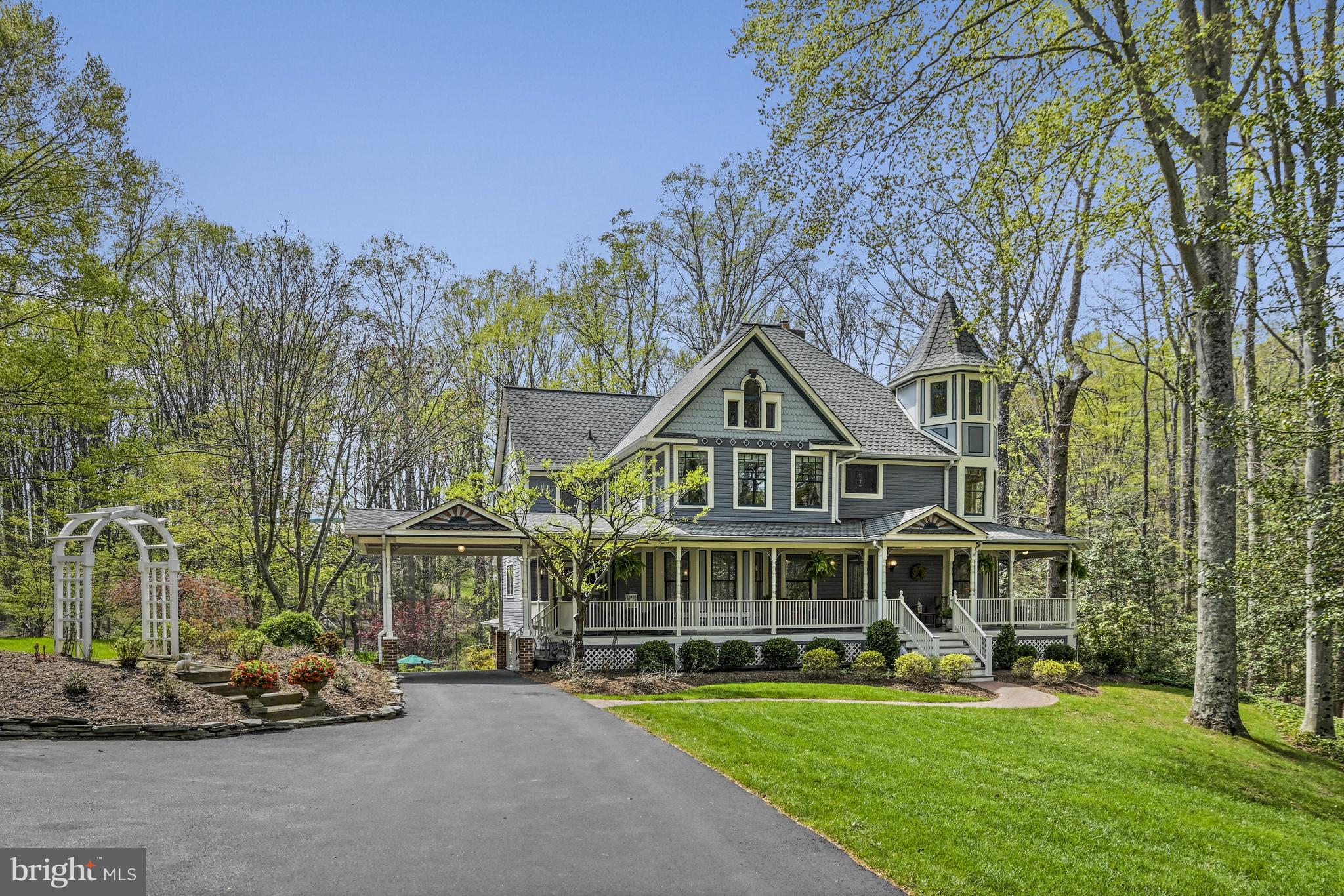 Reintroduced at an Exceptional Value and New Price in Great Falls! Welcome to 204 River Park Drive, a picturesque Neo-Victorian residence set on a beautifully manicured 1.72 acre lot in a premiere location in Great Falls. The property features a 20x40 swimming pool, a large poolside gazebo, stacked stone walls, flagstone garden paths, and lush landscaping with outdoor lighting—creating a private outdoor retreat ideal for both entertaining and everyday enjoyment. Just minutes from River Bend Golf & Country Club, Great Falls Village, and major routes to Reston and Dulles, this exceptional home offers the perfect blend of historical charm and modern living.
Built in 1984 and inspired by vintage floorplan books, this five-bedroom, four-and-a-half-bathroom home with a three-car garage embodies the spirit of America’s “Painted Ladies” while offering 7,000 square feet of thoughtfully designed living space.
Inside, period details abound, including four wood-burning fireplaces with antique mantels, custom-milled solid oak trim and doors, Bradbury & Bradbury wallpaper, stained glass windows, and a 150-year-old front door with Victorian hinges. A grand cherry staircase—reconstructed using parts from an 1880s Washington D.C. hotel—adds timeless character to the entryway and connects all three levels.
The main level offers formal living and dining rooms, a library, a family room with wood-paneled accents, and a recently updated sun-filled kitchen with granite countertops, oak cabinetry, stainless steel appliances, and a walk-in pantry. The breakfast area and sunroom overlook the expansive deck and backyard oasis.
Upstairs, the primary suite features five windows, a wood-burning fireplace, and an updated bathroom with a cast iron soaking tub, frameless marble shower, and double vanity with honed marble countertops. All additional bedrooms include ensuite baths, walk-in closets, and unique architectural elements such as skylights, stained glass, or retractable awnings. The finished top level includes a turreted studio with Palladian windows, a raised platform, and five cedar closets. This space has multi functional use - a studio, bedroom, exercise or playroom.
The walk-out lower level includes a rec room with a fireplace, wet bar, and pool table, plus a guest space, den, and ample storage. Additional features include a wrap-around porch, updated Trex deck, screened gazebo, whole-house generator, and multiple system upgrades.