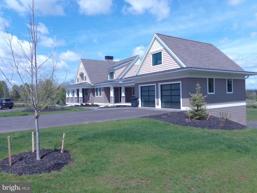 Welcome to a truly exceptional Craftsman estate where timeless architecture meets modern luxury, set on 16.56 breathtaking acres of rolling beauty and serene privacy. This remarkable 4-bedroom, 5½-bath home offers the perfect blend of refined living and relaxed comfort, thoughtfully designed for both everyday enjoyment and unforgettable gatherings. Step inside to discover a warm, open main level filled with natural light and refined finishes. At the heart of the home, the expansive chef’s kitchen is a true showpiece—featuring high-end appliances, generous counter space, custom cabinetry, aesthetically pleasing lighting and an inviting layout that makes cooking and entertaining effortless. Whether hosting holiday celebrations or enjoying a quiet morning coffee, this space was designed to bring people together. The adjoining living area flows beautifully, offering cozy yet sophisticated spaces anchored by Craftsman-style details and picturesque views of the surrounding acreage. Large windows frame the natural landscape, creating a seamless connection between indoor comfort and outdoor beauty. Throughout the home, each of the bedrooms offers privacy and comfort, while the 5½ bathrooms provide convenience and thoughtful design. The luxurious primary suite serves as a peaceful sanctuary, offering ample space to unwind at the end of the day. Downstairs, the fully finished lower level expands the home’s versatility even further. A complete second kitchen makes this level ideal for extended family living, guest accommodations, or effortless entertaining. Whether hosting long-term visitors or creating the ultimate game and movie night space, this level offers endless possibilities. Above the main-level two-car garage, a separate living space provides even more versatility. Perfect for a guest suite, home office, studio, or private retreat, it adds yet another layer of functionality to this already exceptional property. In addition to the main-level garage, a second two-car garage on the lower level ensures abundant storage for vehicles, equipment, or recreational toys.
Perhaps the most enchanting feature of all is the covered porch that stretches across the entire back of the home. This expansive outdoor living space invites you to slow down and savor the views—morning sunrises, golden afternoons, and peaceful evenings surrounded by nature. With 16.56 acres to explore, complete with scenic walking paths, you’ll enjoy privacy, beauty, and room to roam right outside your door.
This is more than a home—it’s a lifestyle. A rare opportunity to own a Craftsman estate where luxury, land, and livability come together in perfect harmony.