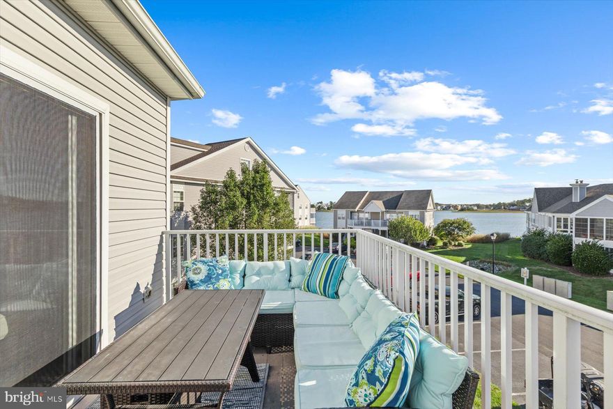 Welcome to your Delaware beach retreat—perfectly positioned in a bayfront community with direct water access! This beautifully furnished 4-bedroom, 3-bath top-floor end unit is truly move‑in ready, radiating coastal charm and effortless style throughout. Just minutes from Bethany Beach, this home offers the ideal blend of serenity, convenience, and investment potential. Step onto the inviting front porch with peaceful pond views—an ideal spot for morning coffee or evening unwinding. Inside, a shiplap-accented hallway opens to a sunlit living room featuring laminate wood flooring, a ceiling fan, and sliders that lead to a private rear deck with tranquil bay views. The eat‑in kitchen offers ample cabinetry, neutral tones, and beach‑inspired décor that ties the space together beautifully. The main level includes a cozy guest bedroom with a full hallway bath, along with a spacious owner’s suite complete with a private bath and ceiling fan. Upstairs, two additional bedrooms and a full bath provide the perfect setup for guests, family, or a home office. Garage #25 conveys with the property, offering secure parking and extra storage. The entire main living area features easy‑care laminate wood flooring, enhancing both style and functionality. Best of all, this home is nestled in an active bayfront community offering an incredible lineup of amenities: golf, a swimming pool, tennis, volleyball, basketball, a playground, bay access, and kayak storage—everything you need to embrace the coastal lifestyle. Whether you're seeking a full‑time residence, a weekend escape, or a rental‑ready investment, this top‑floor gem delivers. Furnished, polished, and ready to enjoy—your waterfront lifestyle starts here.