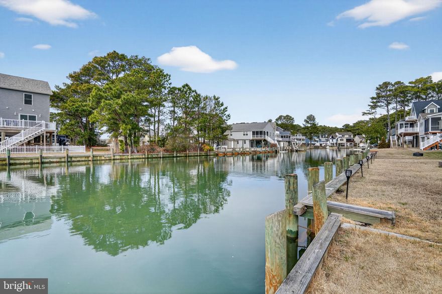 Waterfront living awaits in the amenity-rich Captain’s Cove Golf & Yacht Club! This charming elevated coastal cottage is perfectly situated on a bulkheaded canal-front lot with beautiful water views and direct access for boating, kayaking, paddleboarding, and fishing — offering the ultimate Eastern Shore lifestyle.

Inside, the bright and airy open floorplan features luxury vinyl plank flooring throughout and inviting coastal character. The spacious kitchen and dining area flow seamlessly into the expansive family room with soaring cathedral ceilings, abundant natural light, and a cozy propane corner fireplace. Added in 2019, the oversized family room and screened porch significantly expanded the living space while maximizing the home's connection to the waterfront setting. French doors lead to the screened porch overlooking the canal — the perfect spot to enjoy morning coffee, evening sunsets, and refreshing coastal breezes.

Outdoor living shines with multiple spaces designed for relaxing and entertaining. Beneath the screened porch, a large covered patio creates an ideal shaded retreat for gatherings, grilling, or unwinding after a day on the water. The level grassy backyard extends to the bulkheaded canal frontage, providing easy access to the water and plenty of room for outdoor enjoyment.

The ground level includes a spacious two-car garage plus a finished studio/workspace ideal for a home office, hobby room, workshop, fitness space, or additional storage.

The main level offers a flexible bedroom perfect for guests, an office, or den, along with a full bath and oversized laundry room. Upstairs, two generously sized bedrooms feature walk-in closets and share a convenient half bath, creating comfortable accommodations for family and visitors alike.

Partially furnished and move-in ready, this property offers an easy transition to waterfront living. The boat is also negotiable, creating a rare turnkey opportunity to immediately begin enjoying life on the water.

Captain’s Cove residents enjoy an impressive array of resort-style amenities including a golf course, marina, boat ramp, indoor and outdoor pools, fitness center, restaurant, tennis courts, pickleball, playgrounds, walking trails, and more.