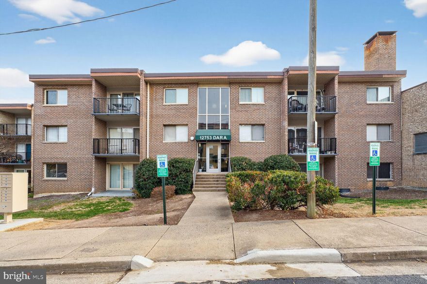 Welcome to 12753 Dara Drive #101, a wonderful ground-level condo in the heart of Occoquan, located in the sought-after Occoquan Ridge community! This inviting unit has been freshly painted, and beautiful hardwood floors extend throughout the living areas and bedrooms. The light-filled living room features a ceiling fan, recessed lighting, and a large window, while the sliding glass door in the dining room adds even more natural light. Step outside to your private patio—perfect for morning coffee or relaxing with a good book. The updated kitchen offers ceramic tile flooring, granite countertops, and stainless-steel appliances, accented by a stylish glass tile backsplash. The hall bathroom includes a crisp white pedestal sink with brushed nickel fixtures, a decorative mirror, and a contemporary light fixture, while the shower is finished with classic white subway tile highlighted by blue and gray glass mosaic accents. The spacious owner’s suite features a ceiling fan and a generous walk-in closet with built-in shelving for excellent storage. This condo includes two parking permits, private storage, and access to shared laundry facilities, and the condo fee covers all utilities (electric, gas, water, sewer, and trash), basic cable, storage, heating and cooling, common area maintenance, snow removal, and an outdoor pool. Ideally situated just minutes from Route 123, I-95, major commuter routes, the VRE, and nearby commuter lots, with convenient access to shopping, dining, Potomac Mills Mall, Sentara Hospital, Kaiser, and the picturesque waterfront town of Occoquan, known for its parks, art galleries, and restaurants.