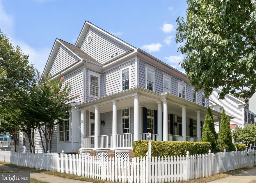 Framed by a white picket fence and a graceful wrap-around porch, this corner-lot Colonial captures storybook charm in the coveted Watkins Pond section of King Farm. With more than 5,000 square feet of living space across 3 levels, the home is ideally set on a premium lot offering tranquil views of a protected natural area and the community pool.
 Inside, soaring 10-foot ceilings and abundant natural light create an immediate sense of openness. The main level moves gracefully from the formal living and dining rooms into the beautifully updated kitchen and breakfast area. Here, crisp white cabinetry, granite counters, stainless steel appliances, and a center island with seating make both everyday meals and entertaining a joy. The adjoining breakfast room, framed by sliding glass doors with transom windows above, flows seamlessly into the family room to create a central hub for gathering. At the heart of the home, the sun-drenched family room features a wall of tall windows framing serene backyard views, generous dimensions that allow for multiple seating areas, and a cozy fireplace that anchors the space with warmth and charm. Just outside, a beautiful Brazilian Walnut deck overlooks the fenced backyard, providing additional outdoor living space perfect for grilling, entertaining, or relaxing with family and friends. Completing this level, a private study provides a quiet retreat—ideal for working from home or reading in peace.
Upstairs, the primary suite impresses with a 10-foot tray ceiling and ceiling fan, a relaxing sitting room—perfect as a lounge or additional office—dual walk-in closets, and a spa-inspired bath with a soaking tub, oversized glass shower, and dual vanities. Two additional ensuite bedrooms complete the main upper level, while a private suite above the garage—with its own staircase, walk-in closet, and full bath—serves as the perfect hideaway for guests, an au pair, or anyone seeking additional privacy.
The finished lower level expands the home’s functionality with a large recreation room, a custom-built movie room with surround sound, a wet bar, and ample storage—including a dedicated storage room with custom racks. A full bedroom and bath on this level make it ideal for overnight guests or extended stays, all enhanced by 9-foot ceilings.
This home has been meticulously maintained and thoughtfully updated: new hardwood floors and carpet (2025), LG washer & dryer (2024), KitchenAid double convection oven (2020), KitchenAid 36" gas cooktop (2016), LG refrigerator and microwave (2016), GAF Timberline HD lifetime architectural roof (2018), LiftMaster 8550WL garage door opener with WiFi connectivity, and extensive ethernet wiring with  20 ports throughout the home, paired with Verizon FIOS fiber service, supports six wired WiFi routers across three levels—delivering lightning-fast, reliable internet for multiple people working and learning from home.
Enjoy the vibrant King Farm lifestyle—directly across from the community center with pool, gym, and year-round events; with school bus stops and the King Farm shuttle to Shady Grove Metro just around the corner. King Farm Village shopping and dining are only two blocks away, with quick access to Route 355, ICC/MD-200, I-270, and Shady Grove Hospital. Don’t miss your opportunity to make this exceptional home yours.