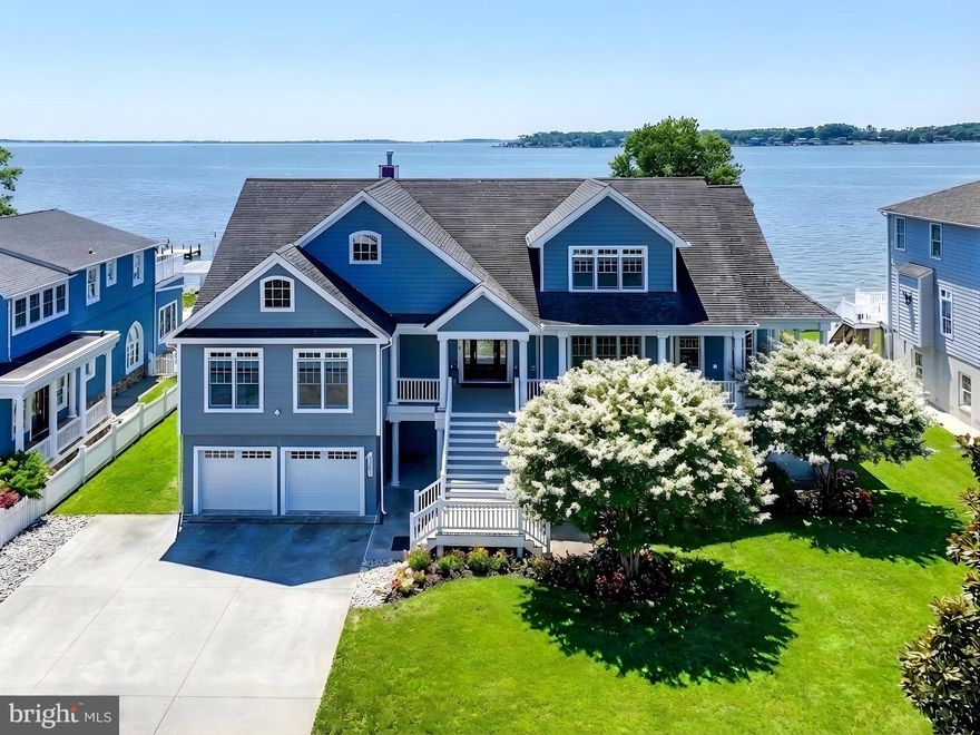 Set along the coveted Bowley's Quarters waterfront, this exceptional custom-built residence commands a premier position on the Chesapeake Bay at the mouth of the Middle River—offering sweeping, year-round water views and an unparalleled setting for both grand entertaining and everyday living. The main level is defined by rich hardwood flooring and expansive windows that flood the home with natural light while framing panoramic bay vistas from the living room, dining room, and kitchen. The kitchen has been thoughtfully reimagined with new countertops, freshly painted cabinetry, and updated appliances, blending modern functionality with timeless appeal. The spacious primary suite serves as a private retreat, complete with direct access to the deck and breathtaking water views, a generous walk-in closet, and an expansive en-suite bath. Throughout the home, five well-proportioned bedrooms—each accommodating king-size furnishings—offer comfort and flexibility, complemented by custom closet systems that provide exceptional storage.

Outdoor living is equally impressive, with premium Ipe wood decking extending across the main level and wrapping around the porch and deck areas, creating a seamless connection to the surrounding landscape. Durable James Hardie Plank siding enhances both aesthetics and longevity, while recent updates—including a new deck awning and stamped concrete walkways. The fully fenced rear yard offers privacy and security, while the 100-foot waterfront is a true boater’s haven, featuring an 8,500 lb boat lift, two jet ski lifts, and a mooring pole—providing effortless access to the bay. Ample parking is accommodated by a spacious concrete driveway for approximately nine vehicles, an attached two-car garage, and a detached two-car garage with loft space, currently configured as a workshop with potential for further customization.

The lower level offers exceptional versatility, featuring a fully finished basement with a full bar, expansive recreation space, a full bath, and an additional bedroom with tranquil water views—ideal for guests or extended living. A rare offering, this waterfront estate seamlessly blends custom craftsmanship, meaningful updates, and direct Chesapeake Bay access—delivering a truly turnkey lifestyle defined by comfort, elegance, and unforgettable views.