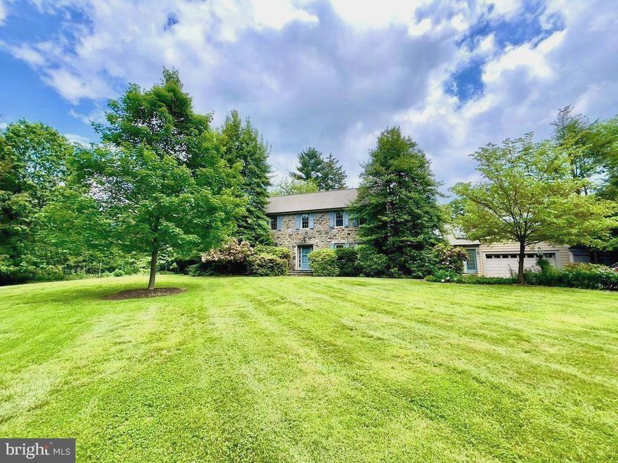 Welcome to 245 Ashwood Road, a classic stone colonial built in 1930, perfectly nestled in the heart of Villanova, Radnor Township. This charming home sits on a beautifully level, open lot adorned with magnificent flowering trees, mature landscaping, and a lush backdrop that ensures privacy on all sides. A carefully tended flower and vegetable garden, complete with protective fencing, adds a touch of pastoral charm. Step inside to find a welcoming foyer with gleaming hardwood floors, leading you to the spacious living room with deep window sills, a cozy fireplace, and two sets of French doors opening to a covered porch. To the right, an elegant dining room invites gatherings, while a tucked-away office and convenient powder room offer quiet work and relaxation spaces. The bright kitchen, featuring a gas cooktop and ample white cabinetry, flows seamlessly into a cheerful breakfast room and a vaulted family room bathed in natural light from floor-to-ceiling windows, doors, and skylights. Upstairs, four bedrooms include a beautiful primary suite with rooftop deck access, a walk-in closet, and an updated bath. Additional bedrooms are generously sized and complemented by a hall bath with a whirlpool tub. A spacious attic, game room on the lower level, attached two-car garage and a private rear patio overlooking the beautiful property complete this wonderful home with sophisticated elegance, in a spectacular setting!  Enjoy the many benefits of this Villanova location while living in a highly desirable, quiet neighborhood that offers convenient access to trains, shopping, and roadways.  Surrounded by the many amenities of Bryn Mawr and Wayne, and the top rated Radnor School District. this property offers an outstanding opportunity in the heart of the Main LIne.