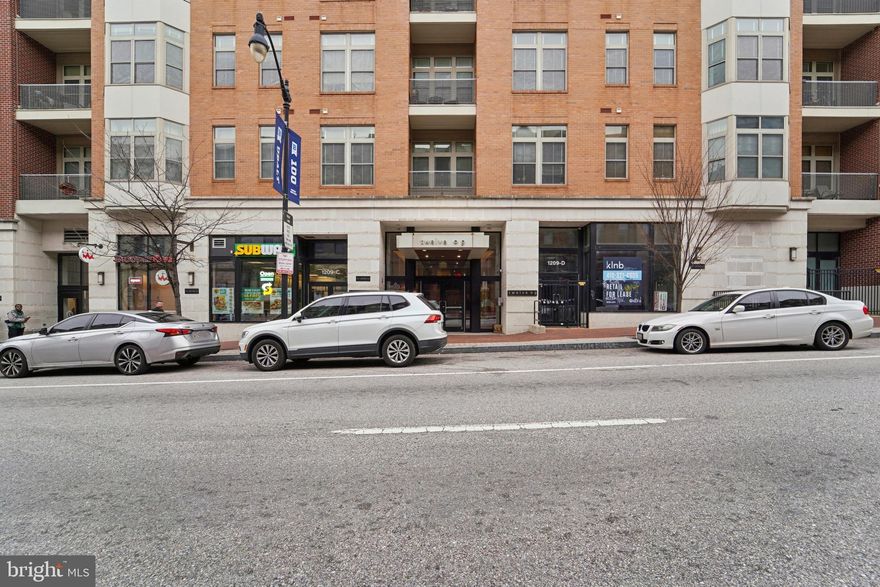 This penthouse-style flat condominium offers a well-designed layout with two bedrooms and one full bathroom. The interior features wood flooring throughout and a spacious bathroom with a large shower and dual shower heads. The kitchen is finished with quartz countertops and complements the open living space. Additional highlights include a private balcony overlooking the courtyard, a walk-in closet, and in-unit comfort provided by central air conditioning with an HVAC system replaced in 2022. Parking is available. Conveniently located near local amenities, dining, and transportation options.