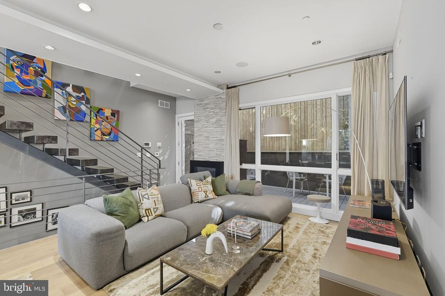 Welcome to 204 W Laurel Street, a home of refined craftsmanship and modern comfort in the heart of Northern Liberties. Nestled within Laurel Court, an intimate community of thoughtfully designed residences, this expansive 3-bedroom, 3.5-bath townhome spans over 2,800 sq ft and offers rare amenities including a roof deck, balcony, private rear patio, and parking for one car. The custom kitchen is a chef’s dream with Thermador appliances, quartz countertops, under-cabinet lighting, and a designer backsplash, flowing seamlessly into a sunlit living room with a gas fireplace and access to the deck. Upstairs, two spacious bedrooms with generous closets share well-appointed hall bath and laundry rooms. The palatial primary suite crowns the third floor with soaring 10’ windows, a walk-through closet, and a spa-inspired bath featuring an oversized shower, soaking tub, and dual vanities. The rooftop level is built for entertaining with a wet bar, powder room, and storage leading to panoramic views. Hardwood floors, recessed lighting, solid-core doors, dual-zone HVAC, and oversized windows enhance every detail. With two years remaining on the tax abatement, this is a rare opportunity to own an exceptional home in one of Philadelphia’s most desirable communities.