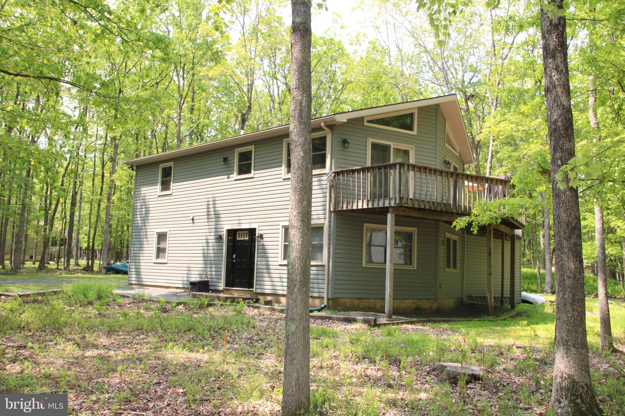 One of the very rare properties for sale with a 1 acre lot in Towamensing Trails! Benefits include a Wrap-around second-story deck offers good outdoor space. The expanded driveway and huge shed are very convenient for lots of parking and outdoor storage. This renovated, well maintained contemporary offers generous room sizes and many living areas on both levels! Welcoming foyer, a large utility room/laundry room ready for work with washer and dryer, 200 amp upgraded electrical panel.....the lower level is complete with two spare bedrooms and 1 full bathroom, along with a ''gathering'' spot. The upstairs features an open concept, with living room, kitchen, and dining space combined, accented with a wood finished vaulted ceiling, and a stone wood burning fireplace.....2 sliders will take you out to the deck. The second floor features two bedrooms, with a full hall bathroom. 2023 new vinyl siding and 17 replacement ECO windows, and 2 sliding glass doors. Cellular pull-down shades throughout. The roof is only 6 years old. The septic pump and alarm are one year old, Hot water heater 2 years old. Home is conveniently located off the new 903 Exit, a short drive to the ever-popular Jim Thorpe Area, restaurants galore, the Pocono Mountain attractions, and outlets..The development offers a clubhouse, pool, beach area, paddle boats, marina with 2 docks , fun community events, trash drop off, and security..