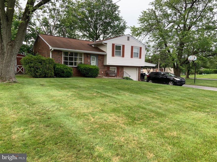 This charming Colonial Split Level home, built in 1965, offers a blend of classic design and modern functionality, situated on a spacious 0.45-acre corner lot in the desirable Center Square neighborhood. The home boasts four well-appointed bedrooms and two and a half bathrooms, including a stall shower and a tub shower for versatile bathing options. The inviting eat-in kitchen features a table perfect for casual dining and is equipped with essential appliances, including a gas cooktop, wall oven, and refrigerator. The dining area is ideal for entertaining, while the recessed lighting in the basement enhances the ambiance. Enjoy the warmth of wood floors and the convenience of walk-in closets for organized storage. The fully finished basement, with heated interiors and garage access, provides additional living space and functionality. The exterior is highlighted by brick construction and thoughtful landscaping, including a well-maintained front yard and a spacious rear yard, perfect for outdoor activities. The property features a carport that connects the home to the attached garage, providing covered access. Additional outdoor amenities include exterior lighting, sidewalks, and street lights, enhancing both safety and aesthetics. The level lot offers plenty of space for gardening or recreational activities, with side yards and a rear yard that provide privacy and room to roam. A shed on the property adds extra storage for tools and outdoor equipment. Parking is abundant with an attached garage, carport, and additional driveway spaces, accommodating multiple vehicles with ease. Enjoy serene views of the garden and lawn from various vantage points around the property, creating a peaceful retreat right at home. This property combines comfort, functionality, and outdoor space, making it an ideal choice for those seeking a well-rounded residential experience. Don't miss the opportunity to make this charming home your own!
