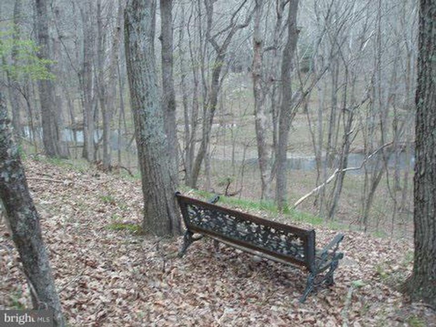 2.86 Acre  wooded lot in Southern Morgan County.  Located in a well maintained subdivision with frontage on the Sleepy Creek but with a building site out of the flood plain.  Water view in the winter.   Perfect for either full time or vacation home.  Seller had a septic permit, but let it expire.