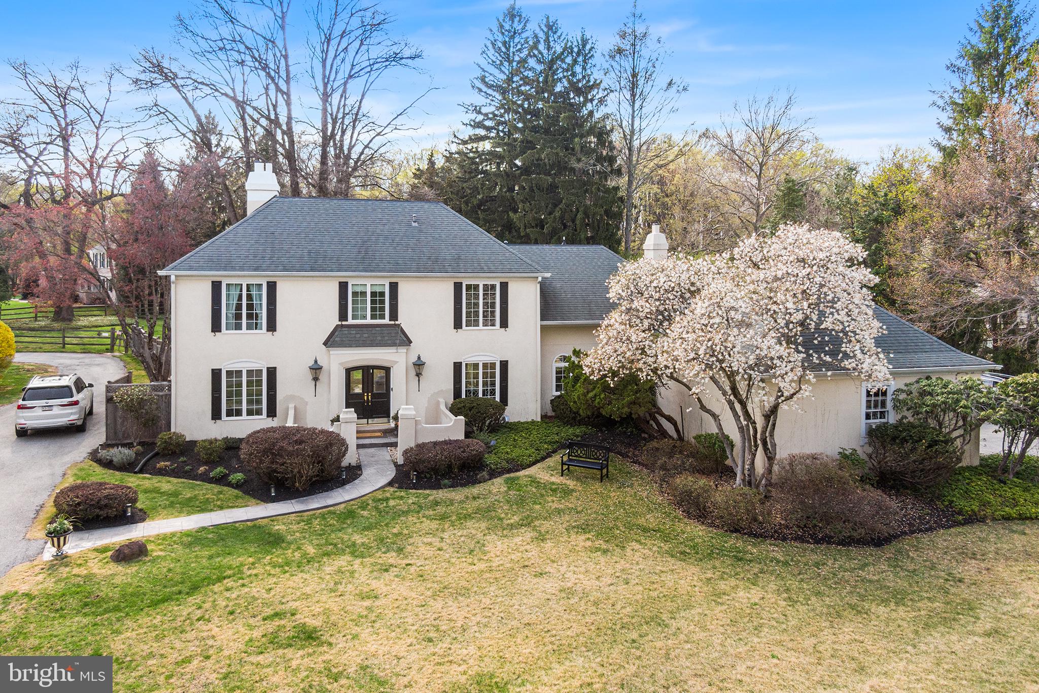 Welcome to this extraordinary mini-Château in the heart of Devon—where timeless design meets modern luxury in the award-winning Tredyffrin-Easttown School District. This exceptional estate offers a total of 5 bedrooms and 4.5 bathrooms across two beautifully crafted homes, nestled on a pristine, private 1.1-acre lot. The main residence boasts 4 bedrooms and 3.5 bathrooms, showcasing rich architectural detail and elegant finishes throughout. Step inside and be greeted by wide-width hardwood floors, custom millwork, stylish banister, intricate moldings, and wainscoting. The inviting living room, complete with gas fireplace and French doors, opens to the serene backyard—perfect for indoor-outdoor living.
The kitchen is a Chef’s dream: marble countertops, custom cabinetry, an 8-burner gas cooktop with double ovens and steamer, double sinks, two dishwashers, and a large island with wine fridge. The sunny breakfast area includes built-in banquette seating. Adjacent to the kitchen, the dining room offers built-ins, more recessed lighting and flows seamlessly into a spacious family room featuring exposed wood beams, built-in bookshelves, and a second gas fireplace. A well-designed mudroom with cubbies leads to an attached two car garage and a separately fenced side yard, ideal for pets or gardening, away from the entertaining rear yard space.
Upstairs, the luxurious primary suite includes recessed lighting, a walk-in closet with built-in drawers and a sit-down vanity. The bathroom is like entering a spa featuring a double vanity, steam shower with rain shower head and bench, and a private water closet. An additional en-suite bedroom, two more bedrooms with a shared hall bath, and a walk-up attic for storage complete the second level.
The finished lower level offers a versatile retreat with a large playroom, home gym, laundry area, and an egress window for natural light. Out back, escape to your own private oasis: an in-ground pool with diving board, stone fire pit for cozy evenings under the stars, and a separate two-story guest house featuring a living area with kitchenette, upstairs bedroom, and full bath—perfect as an au pair suite, extended family & guests, or a private office/studio space. Additional features include public utilities, natural gas (PECO), a whole house, gas backup generator, water softener system, updated roof, JELD-WEN windows, and low annual taxes—making this a true turnkey property. Located minutes from major highways, shops, dining, and the train station, this estate offers both tranquility and accessibility. Schedule your private tour today and experience luxury living at its finest.
