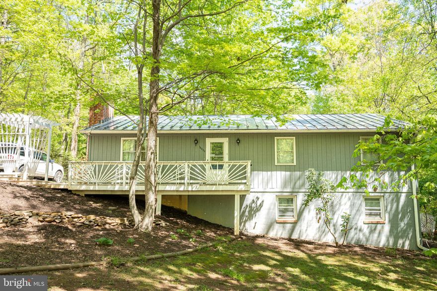 PRICE REDUCED!! Wonderfully located secluded home in a wooded sub-division at the base of Bull Run Mountain. This metal-roof house has a main level with an eat-in kitchen, 3 bedrooms, 2 full bathrooms, and a family room with gas insert fireplace that can be converted back to a wood burning fireplace. The lower level has 2 more bedrooms (not to code due to window height), 1 full bathroom, laundry room, unfinished addition, and large family room with a bar and wood burning stove. Outside boasts a large screened porch (12'x48') and a huge detached garage (20'x36')  with second level storge, wood burning stove 100amp service, and the space to fit 2 vehicles! You do not want to miss this home with NO HOA located close to shopping and schools!
