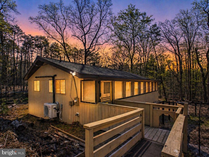 Affordable, turnkey, and quietly nestled in The Woods subdivision—this inviting chalet is the opportunity you’ve been waiting for. Situated on a spacious .91-acre lot, this 2-bedroom, 1 full bath home blends cozy charm with meaningful updates. Backing directly to the Sleepy Creek WMA, you’ll enjoy access to over 23,000 acres of scenic wilderness—an outdoor enthusiast’s dream right outside your rear door. Whether you’re a hunter looking for nearby game lands or a golfer ready to tee off, this location delivers.

Inside, you’ll find durable LVP flooring throughout and a tastefully renovated bathroom, offering a clean, modern touch. The comfortable living area features a wood-burning fireplace, perfect for quiet evenings or weekend escapes, while the updated rear laundry room adds everyday convenience.

Key improvements include an architectural shingle roof (2018), vertical vinyl siding (2020), upgraded 6” gutters, crawl space encapsulation with added storage, and a (2024) mini-split 3-head system for efficient year-round comfort.

Take in the peaceful setting from the screened porch—ideal for morning coffee or unwinding at the end of the day. Whether you're searching for a primary home, a weekend getaway, or a smart investment, this well-maintained home checks all the boxes.

Don’t miss your chance to own in The Woods—schedule your showing today. Property has a Class B membership to The Woods community amenities, featuring access to the recreational center and community pools.