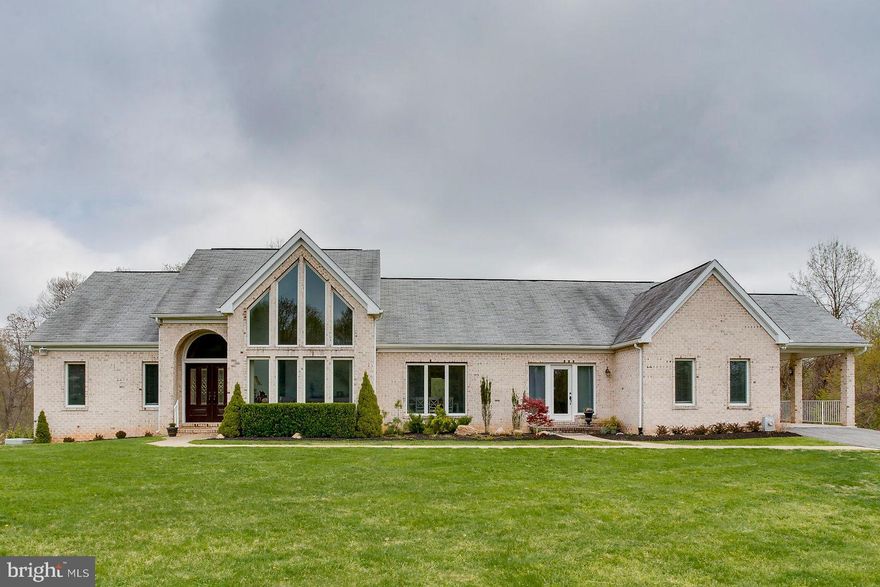 Unique and spacious home situated on almost one and half acres in a coveted and quiet neighborhood.  Diverse living area on the main level features gleaming hardwoods throughout, cozy living room with wood burning fireplace, formal dining room, sitting room with 20' ceilings, laundry room and recently updated powder room.  Gourmet kitchen has been updated with top of the line stainless steel appliances, custom cabinetry and granite countertops leading to the breakfast room and adjacent main level guest room with full bathroom.  Main level master retreat with new, modern master bathroom.  Lower level features PLENTY of living space including 4 well-sized bedrooms, 2.5 baths, 2nd laundry room, a workout room, game room and family room with walk out access to the sprawling backyard.  Impressive utilities including three zoned HVAC system and dual propane water heaters.  Sprawling front and rear yards, two car attached garage, large rear patio and updated hardscaping.  Luxury living with all of the modern amenities and a private, country feel!