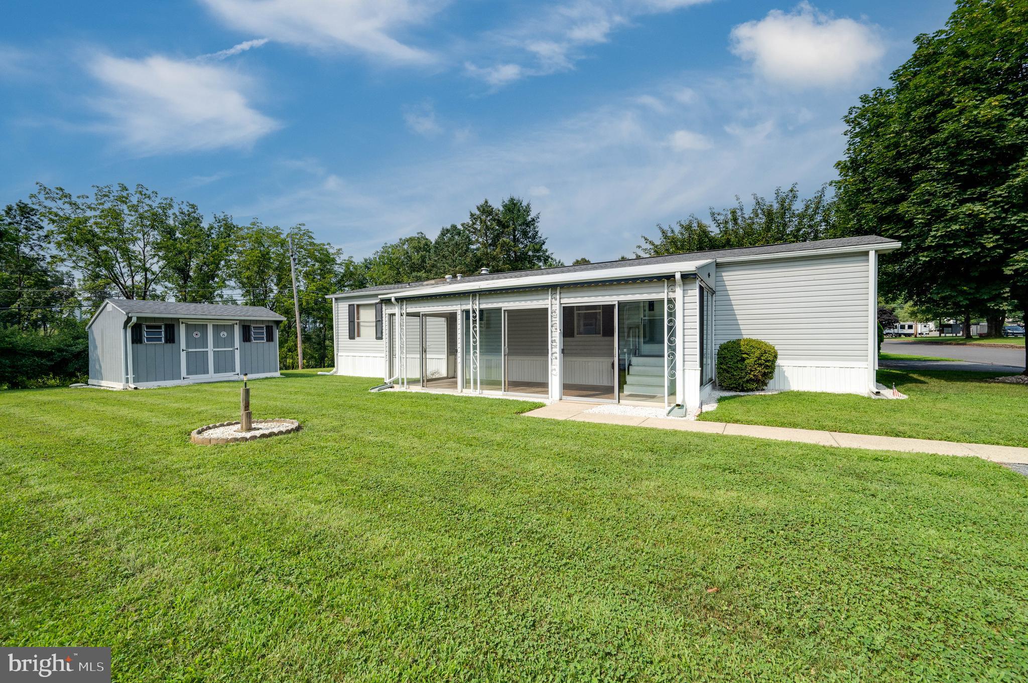 Available for quick possession, this manufactured home is situated on Lot #M50 and is nestled in the hills of Upper Bern Township in the community of Mountain Springs mobile home park and campground. The home offers a welcoming covered 3 season porch with sliding patio doors and leads into the spacious living room that is open to the kitchen. There are two bedrooms which are situated at opposite ends of the home for privacy. Bedroom 1 has a half bathroom, and Bedroom 2 has two closets and is located next to the modern, full bathroom with walk in shower. The washer & dryer are located next to the kitchen and back door. The exterior of the home has a spacious yard, storage shed, and off-street parking. Property is being Sold AS IS.
Community amenities include a community pool, covered picnic area, playground, and dog park. The association fee includes common area maintenance, road maintenance, snow removal & trash. Community Water & Sewer are available for a minimal fee per person. All occupants over 18 must make park application and be approved by the HOA.