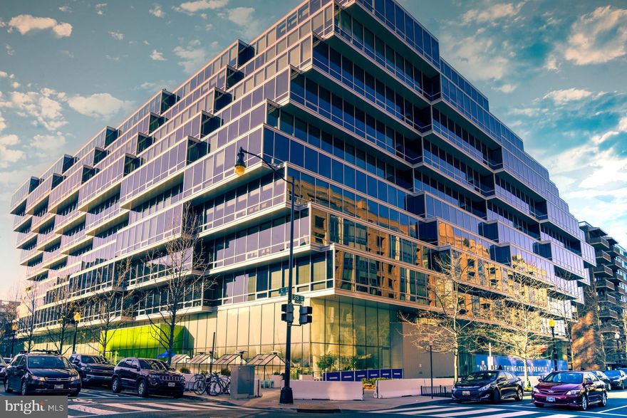 Experience unparalleled elegance in this 2-bedroom, 2-bathroom luxury condominium with a versatile *DEN* and two private parking spaces with Tesla charger. Located on the coveted 9th floor of the Westlight, a LEED Gold-certified masterpiece of sustainable design. A true TURNKEY solution with the option to purchase the furnishings, this 1,782-square-foot south-facing luxury residence offers some of the best open views in the building and is bathed in natural light. Triple-glazed window walls provide exceptional noise reduction, while Low-E glass enhances energy efficiency and UV protection. Designed by internationally acclaimed architect Enrique Norten, the interiors feature natural oak wide-plank hardwood floors, recessed lighting, a Euro-chic kitchen with Italian high-gloss cabinetry, high-end stainless steel appliances and quartzite countertops. A central kitchen island seamlessly flows into the dining and living areas, framed by stunning southern views through floor-to-ceiling windows finished with luxurious automated window treatments. The oversized primary bedroom serves as a private sanctuary, complete with a spa-inspired ensuite bathroom featuring a walk-in shower, a spacious walk-in closet, and an additional secondary closet for ample storage. The generously sized second bedroom also offers a walk-in closet and is complemented by a sleek, contemporary full bathroom. The den is conveniently accessed just off the living  room and dining area and boasts designer wall paper that's also featured in the entrance hall.  Westlight residents enjoy white-glove services, including a 24-hour concierge, doorman, and porter. Amenities include a 25-meter heated rooftop pool with panoramic views, a fitness center with Peloton and Technogym equipment, private parking, a clubroom with a catering kitchen, and more. The breathtaking lobby features a 50-foot living green wall and a lighting sculpture by artist Ingo Maurer. Nestled in DC’s prestigious West End, The Westlight offers a perfect blend of cosmopolitan convenience and tranquility. Steps away from Georgetown, Dupont Circle, and Foggy Bottom, the neighborhood boasts luxury dining, cultural landmarks, and access to Rock Creek Park’s scenic trails. Combining luxury, sustainability, and wellness, this turnkey residence epitomizes the refined urban lifestyle.