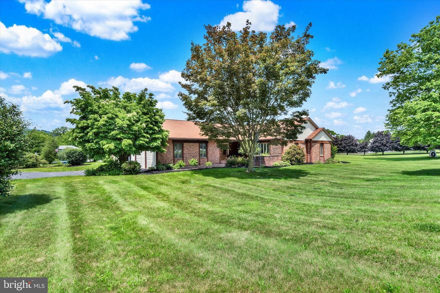Welcome to this beautiful brick ranch situated on a sprawling 1.34 acre lot in Cumberland Valley SD! Totaling over 3,320 square feet of finished living space with an ideal open floor plan, this home is filled with amazing features and many updates throughout. Step inside the grand entrance foyer which leads into the newly updated spacious eat-in kitchen with luxury plank flooring, tile backsplash, quartz countertops, ample cabinet space, large island for prep space, skylights, stainless steel appliances and a breakfast nook with bay window.  Make your way into the family room which features LVP flooring, ceiling fan and a floor to ceiling brick wood burning fireplace. Sunroom with handcrafted vaulted wood ceiling, an amazing space to sit and watch the seasons change with access to the outdoors, a tiered patio that overlooks the in-ground swimming pool surrounded by private fencing. Home features 4 bedrooms and 3 full baths. Primary bedroom includes luxury plank floors, window treatments, ceiling fan and a propane fireplace. Primary bath offers a walk in closet, shower and vanity.  Main bathroom features a jacuzzi tub, shower and large double sink vanity. A large den or living room area that makes a cozy space for relaxation.  Side entrance that offers a mud room with tile floors and a oversized built in cabinet for storage.   An outdoor paradise awaits with the L-shaped pool provides an amazing space for outdoor enjoyment with 9' at the diving board to 3' at the built-in stairs. Shed for storage or pool supplies. Main level laundry. Unfinished basement, which can be accessed from the oversized two car garage with built-in cabinets, provides plenty of additional storage space. Conveniently located to shopping, dining and entertainment. Some newer windows. New pump in the pool. New front door. New wainscoting. Home has been freshly painted throughout. A joy to own!