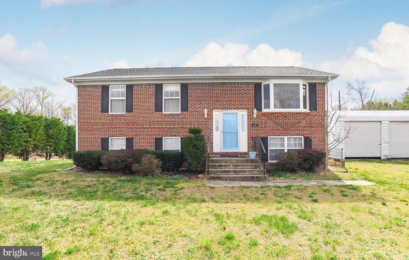 100% financing available. Privacy Galore!!! Brick front home situated on 3 private acres right outside of La Plata. Gleaming hardwood floors throughout upper level. Kitchen, separate dining room, living room...ready for your personal touch. Doors from dining room leads to deck w/ stairs...overlooking large level private backyard. 3 bedrooms 2 bathrooms on upper level w/ ceiling fans. Lower level boasts family room, kitchenette, two additional bedrooms, full bathroom and laundry. Basement slider leads to patio under deck. 4 car detached garage...will be any mechanics dream!! Enjoy country living at its best with just a short drive to shopping, dining, and more! No HOA!