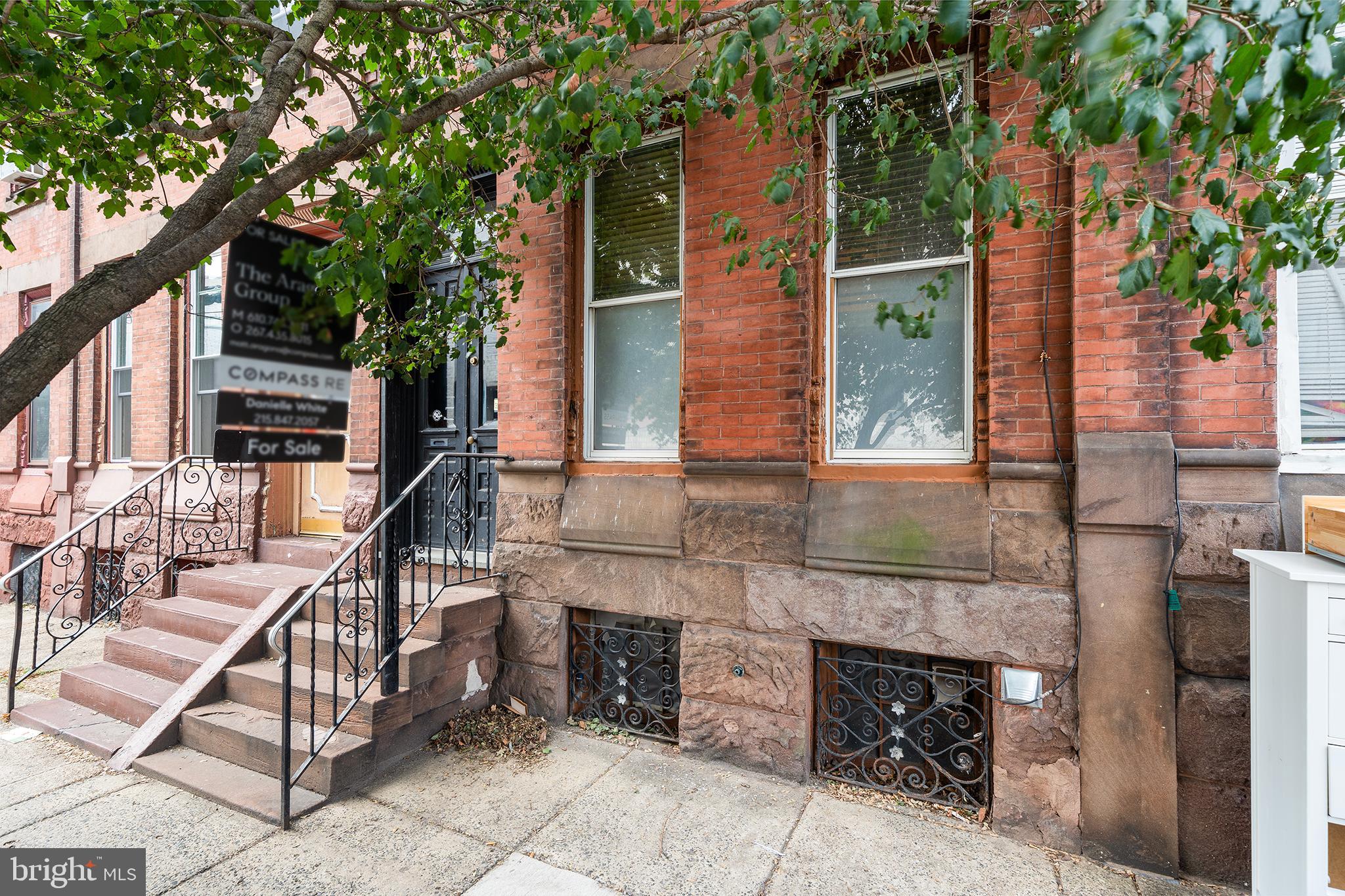 Nestled one block west of Broad Street this stately brownstone has been preserved with remarkable care, keeping its rich history and original character interwoven with slick modern updates. Highlighting original vestibule tiles, original Victorian stained glass transom, 3 sets of glass-paned french doors, rich rustic wood flooring and beautiful original doors throughout. Designed with an architects refined eye the existing color scheme is muted and natural in this well maintained home. You enter the home via broad brownstone steps and classically styled wooden french doors. Into a charming vestibule with antique crazed tiling and beautiful stained glass transom. Light streams through the second pair of frosted glass french doors into the home's foyer illuminating the hall and living spaces. Original flooring throughout gives a warm and rustic feel to this level. You are greeted by an engraved original solid wood stairwell and the living room via the home's traditional layout. The living room boasts a black carved wood and marble fireplace stealing the show in this sizeable space. Moving through the hall the adjoined dining and kitchen spaces are edged with newer Pella windows. The home has a fully modern kitchen and integrated dining area with tasteful lighting. There is a subtle industrial feel to the space via soft toned steel and glass faced cabinetry, under counter lighting and functional outlet placement for appliances. The dining area can seat 6 and the space also boasts a butcher block seating counter. With a well designed intuitive layout, the kitchen has plenty of counter space and two sinks. Complete with stainless appliances including fridge, microwave and dishwasher. The back of the kitchen is delineated with architectural detail providing a nook for the refrigerator, 2nd sink and huge windows. Use this space as an indoor herb garden or fill with house plants to take full advantage of the sun steaming in. The kitchen's side door takes you to a cozy back patio perfect for a cafe table and chairs. Stow trash along the side patio which includes a hose bib. Moving up the front stairwell you find two nice size bedrooms and modern hall bath. The front bedroom features an original built-in Eastlake-inspired wooden wardrobe encompassing one wall with space for a queen size bed. You enter the back bedroom through the home's third set of original frosted glass french doors. This room has another exquisite carved black fireplace, custom window shades and nook with plaster detail hosting a large bay window. All giving the room an understated refinement and cozy restful vibe with space for a queen size bed. The hall bath has natural green slate floor tiles, a custom feel to the MCM wood vanity and ceramic tile with thin natural stone slab walls and shower surround. The third floor of the home is open and unfinished with new wiring and a fully designed and plumbed full bath offering a wiped clean slate ripe for the creative buyer's vision. Superb location-Steps from local favorites like South Philly Tap Room, Ultimo Coffee, Second District Brewing, & Okie Dokie Donuts.1 block from Passyunk Ave main corridor, 2 blocks from Le Virtue, 3 blocks from Barcelona Wine Bar, 2 blocks from the Philly Food Coop. 3 block walk to either Tasker/Morris or Snyder Ave BSL stops. Make this nuanced Victorian townhome full of character yours today!