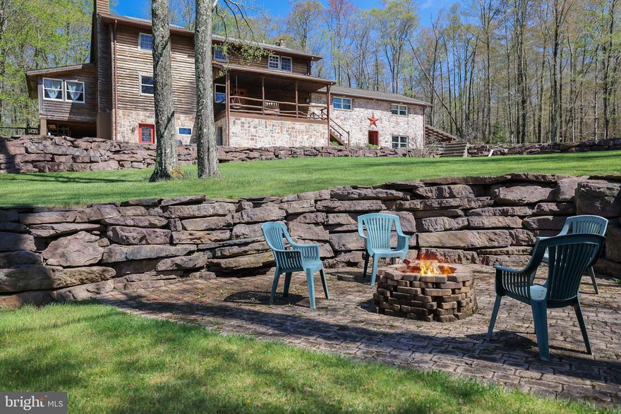 Tucked away on over 5 acres of unspoiled Pocono wilderness in Albrightsville, this isn’t just a home, it’s a chance to own actual breathing room. Five separate parcels give you the flexibility to expand, sell, or simply enjoy knowing no one’s building on top of you. Two of those lots are likely ready to build on now, if you want to create income through vacation rentals or bring friends and family closer (without actually having to share a roof).
The main house is big - over 3,500 square feet - with 3 legit bedrooms, 4 full baths, and two “bonus rooms” currently used as offices. But the real story is how it was built. Portions of the wood and stone were harvested right from the property, giving it a rugged, honest feel that matches the surroundings. It’s warm, solid, and built for a life that doesn’t need to scream to feel significant. Inside, hardwood floors run throughout the lower level. A wood stove can heat nearly half the house by itself, and if you’re more into convenience than chopping logs, the 500-gallon oil tank or the external wood furnace have you covered. Need a break? Step into the 3-season room, fire up the hot tub, and take in your fenced-in, half-acre backyard—perfect for dogs, kids, or just your own peace of mind. There’s also a massive two-car garage, currently set up as a pro-grade woodworking shop with built-ins, power, and space to actually do stuff—not just store boxes. You’re 30 minutes or less from Big Boulder, Jack Frost, and Blue Mountain ski resorts—close enough for weekend trips, far enough to keep the noise away. Hickory Run State Park is right nearby if you’re the hike-until-dinner type. And when it’s time to rejoin civilization, the PA Turnpike is 7 minutes away, Route 80 is 10. This isn’t suburban polish or vacation-home gloss. It’s real space, real quiet, and real potential for income, escape, or just finally living how you want. Sale includes multiple parcels: 21A-51-A21, 21A-51-A18 (Fern lane), 21A-51-A20, 21A-51-A22, 21A-51-A23.