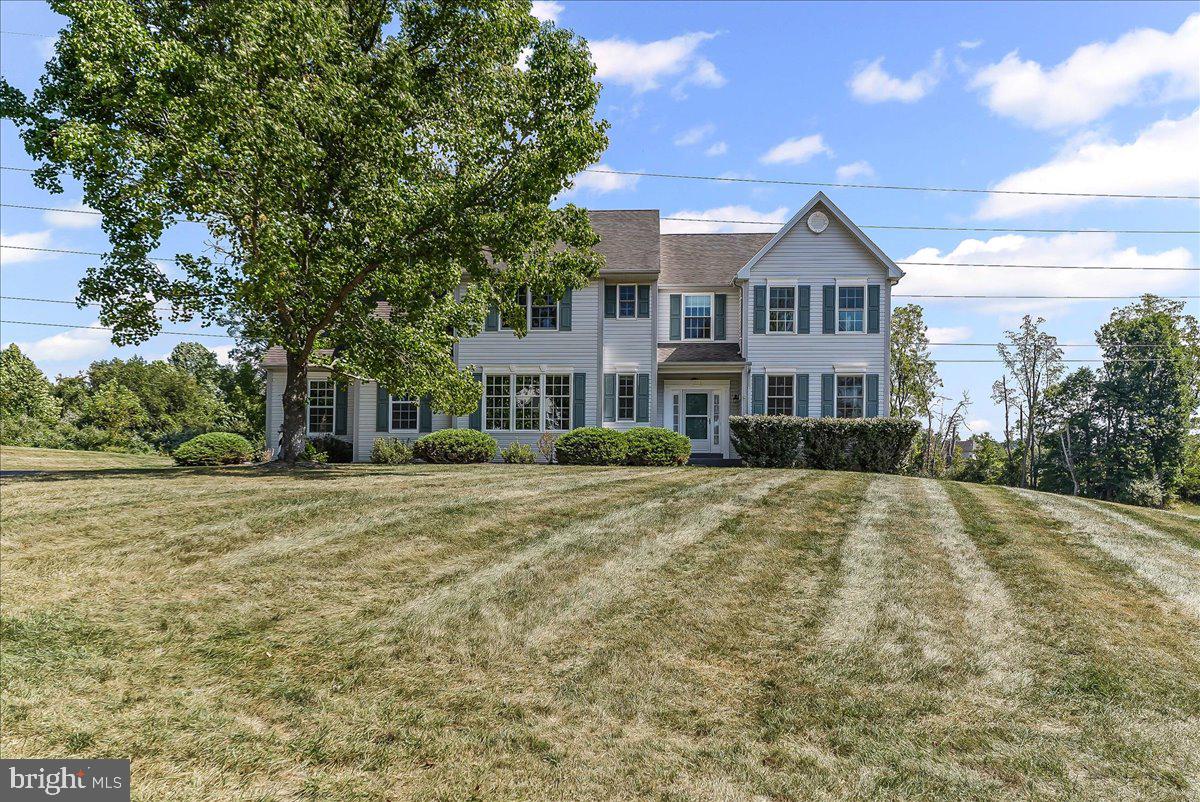Set on a high 1.8-acre open lot, with far reaching views, is this generous sized colonial that awaits its new owners. Dramatic 2 story foyer greets all who enter. Family room, with wood floors and a propane fireplace, is the perfect gathering spot on a cool evening. Living room, with wood floors and the elegance of crown molding, opens to the formal dining room that features wood floors and chair rail—combined they create a perfect entertaining area. Eat in kitchen is located in the center of the home. Wood floor, double sink and breakfast room are enhanced by a pantry, stainless dishwasher and propane range for those serious chefs. Doors open from the breakfast area to the large deck and covered porch -a perfect place for your evening meals or morning cups of coffee. Laundry room opens off the kitchen and doubles as a mud room when coming in from the garage. Powder room completes the first floor and allows for easy access by family and guests. Generous sized primary bedroom features hardwood floors, a walk-in closet and a garden style primary bath with a soaking tub, double vanity, walk in shower with glass door and new luxury vinyl plank floors. 3 additional bedrooms are generous sized and served by a hall bath with a tub/shower and vinyl floor. Large bonus room, on the second floor, could work as an office, playroom, hobby room, movie room or whatever you need. Hardwood floors, ceiling fan and electric fireplace are in place from the sellers’ former use as a well loved study. Additional features and updates include 9-foot ceilings, replacement windows, updated plumbing in the kitchen and baths and a newer well pump and pressure tank. Propane hot air heat comes complete with a built-in humidifier and air cleaner. Lots of cabinets in one side of the garage is perfect if you need a workshop or extra storage!