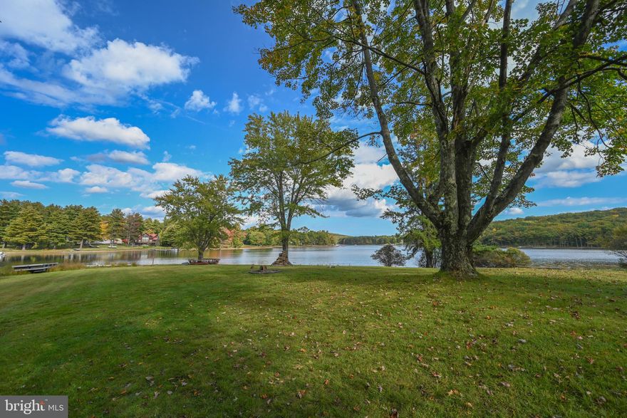 Original Deep Creek cottage with an amazing 323' of pristine lakefront on beautiful Paradise Cove!   Discover this sublime waterfront sanctuary, looking toward the sunrise, unequaled with the ultimate end-of-street privacy location, featuring breathtaking water views, expansive level lakefront lawn, and private Type A dock.  The cozy cottage includes hardwood floors, knotty pine walls, brick wood burning fireplace, and covered lakeside deck.  Realize the potential of this one-of-a-kind property for your future new construction estate home in the majestic mountains of Western Maryland.  Experience lakefront perfection as you make and share memories with family and friends that will last a lifetime.