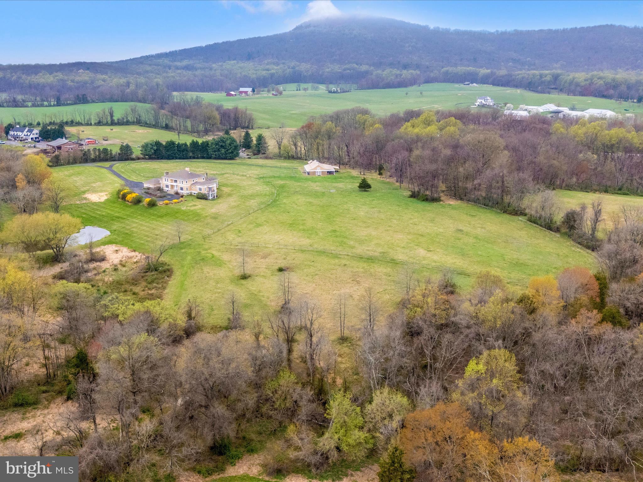 WELCOME TO COMUS RUN, 45.78+/- acres of bliss and views in the heart of the Agricultural Reserve! THIS PROPERTY FEATURES a one-owner well-maintained HOUSE, a BARN/HORSE STABLE, STOCKED POND, DISTANT PANORAMIC VIEWS, STREAM, SPRING (field stone-ringed), OPEN FIELDS, and MATURE FOREST. . . . There are sweeping VIEWS of Sugarloaf Mountain from the back of the house; the front of the house overlooks a wooded ravine and pond with expansive vistas beyond. . . . The BARN has 5 stalls, wash stall (hot and cold water), feed room, tack room, rubber floor mats, lean-to and hay loft. There is a 20x60 meter outdoor sand dressage/riding arena, split-rail fenced flat paddocks, cleared trails, and plenty of pasture land for equine enthusiasts for riding and hay production! EXTENSIVE CLEARED TRAILS ON THE PROPERTY also connect to those on nearby Sugarloaf Mountain. The Potomac Hunt often met at the property and 5K cross country races were hosted yearly onsite on a race course of forests, fields, and stream crossings…. COME INSIDE THE HOME to find it is ready for entertaining with wood floors, high ceilings, large family/living rooms, a grand dining room, library, etc... Custom-designed by highly regarded architect Thomas Manion, the main level also has a separate wing with a full-size primary suite with a grand bathroom, 2 walk-in closets, a balcony, and plenty of space. Upstairs there are four large bedrooms and two full baths with lovely views of the property. There are two staircases leading to the expansive basement which features a small kitchen, two full bathrooms, multiple finished rooms, recreation area, fireplace with wood stove, built-in wall safe, storage rooms, and is walk out to ground level. The home is equipped with a 3 zone HVAC Geothermal heat pump system, 800-amp electrical service, and an automatic generator. . . . THE EXTERIOR OF THE HOUSE features a parking area, paved circle driveway surrounded by landscape, a covered front porch, a large wooden deck facing Sugarloaf Mountain, a balcony off the primary suite overlooking sweeping pasture and wood lines, and a covered back porch. The garage has plenty of room for 3 cars and storage. The home's roof was replaced 6+/- years ago, many windows and doors were replaced about 2 years ago, the septic system was replaced last year, the exterior of the house was just repainted, the basement has new carpet, and there have been many other recent improvements. . . . GREAT COMMUTING LOCATION! The Property is a short drive to I-270 so you can get to Frederick, Rockville, and DC quickly and the MARC passenger train is close by with passenger service to Rockville, Silver Spring, and DC. Property is located in the Poolesville School Cluster!! Shopping is a short drive to Urbana or Clarksburg. Sugarloaf Mountain Vineyard, Comus Inn, Sugarloaf Mountain, Potomac River, C&O Canal, and Monocacy Aqueduct are all right around the corner! This home is ready to move in and enjoy! Call the local listing agent for an exclusive showing today. . . .