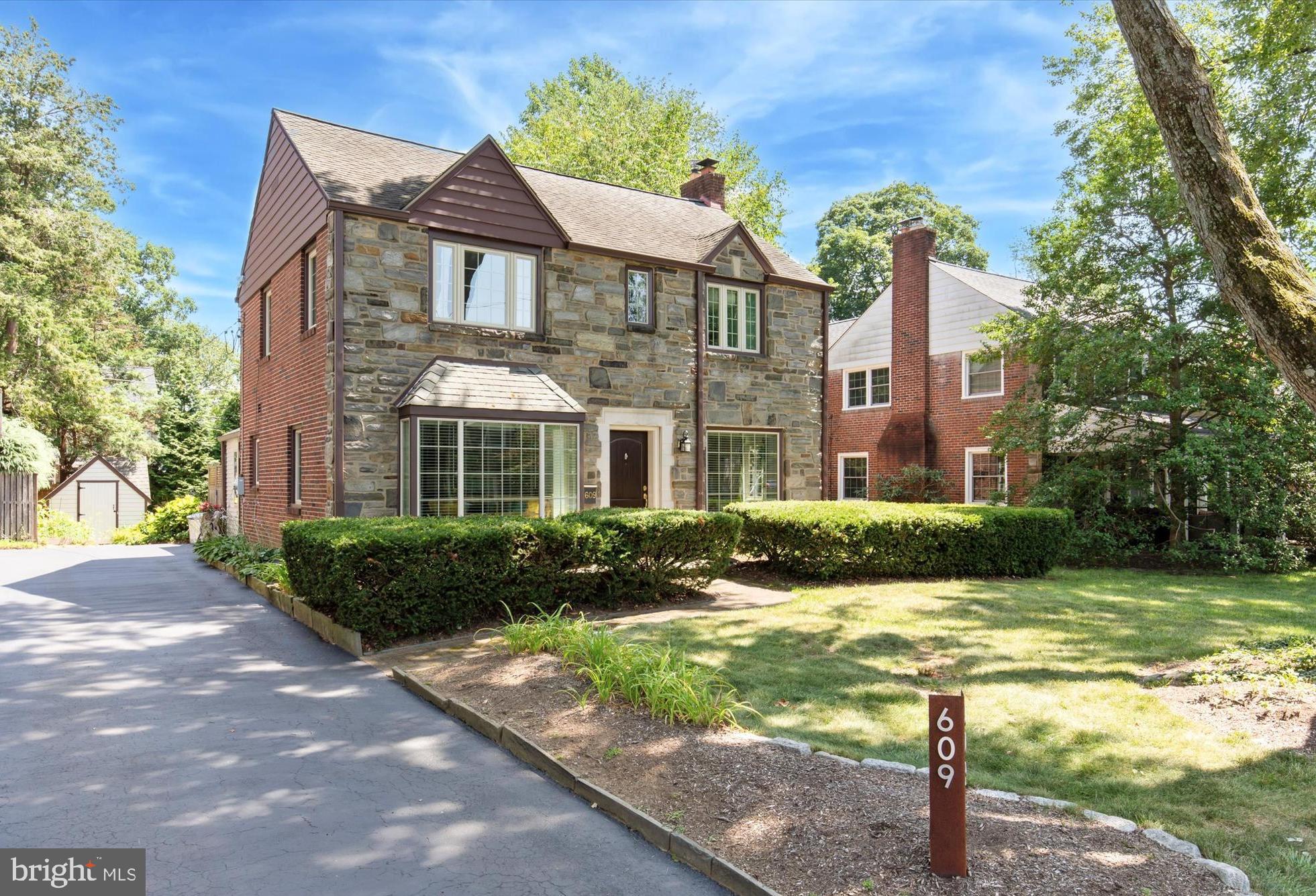 Welcome to 609 Fariston Drive – A charming stone front Colonial on one of the best blocks in Wynnewood. Nestled on a quiet tree-lined street on the prestigious Main Line, this exceptional 4-bedroom, 2 full and 1 half-bath home offers close to 2,500 square feet of beautifully appointed living space on lush, flat grounds with mature landscaping. Thoughtfully designed and renovated, this turn-key home combines timeless elegance with modern comfort, all within the award-winning Lower Merion School District. Step through the front door into the foyer featuring hardwood floors that continue throughout the main level. To the left and right of the foyer are a light-filled formal dining room, ideal for hosting memorable gatherings and a spacious living room with wood-burning fireplace. Continue to the fully renovated family room and adjoining kitchen, boasting bright white cabinetry, granite countertops, and tile backsplash. An island with sink & dishwasher, anchors the space and provides additional prep space and seating. A well appointed drop zone and powder room complete the first floor. Head upstairs to find the primary bedroom with an expanded & remodeled ensuite bathroom featuring a glass-enclosed shower and dual vanity with granite countertop. Three additional bedrooms with ample closet space, and a renovated full hall bath with shower/tub combo & waterfall granite countertop vanity, complete the upper level. The partially finished basement is equally impressive, featuring a second family/media room, kitchenette, pantry, dining area, storage closet, and laundry. The unfinished portion provides a workspace, complete with workbench and utility sink. Step out onto the paver patio overlooking your own private oasis—this serene backyard sanctuary is a nature lover’s dream. Thoughtfully landscaped with a rich tapestry of native plantings, the garden offers year-round beauty, low-maintenance care, and vital support for local pollinators. Located just minutes from South Ardmore Park w/ newly renovated playground, Suburban Square, top-rated schools, and with easy access to Lancaster Ave & the Wynnewood train station, for a quick commute to Center City, this is your opportunity to make 609 Fariston Drive your forever home—schedule your private showing today!