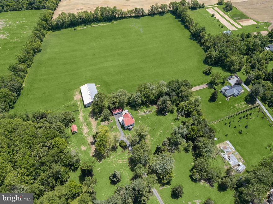 Welcome to 8805 Reichard Road, a rare and exceptional 77-acre historic estate nestled in the heart of Washington County, Maryland. This expansive and picturesque property offers a unique blend of rural charm, functional agricultural infrastructure, and extraordinary potential for personal, commercial, or equestrian use.
Originally constructed circa 1867, the stately farmhouse spans over 3,000 square feet and showcases a stone exterior and timeless craftsmanship inside with original hardwood floors, six wood-burning fireplaces, one gas fireplace, and charming details throughout. The traditional layout includes three bedrooms, two full bathrooms, and one half-bath, along with a formal living room, music room, and dining room. The main level floor plan also offers a central kitchen, fully upgraded with cabinetry, granite countertops, stainless steel appliances and a gas fireplace.  The spacious kitchen is sided by a large family room with a secondary side entrance, and a sun-filled breakfast room with access to an expansive rear dining deck, both ideal spaces for gatherings large and small.
The land is the true crown jewel of this offering—nearly 77 acres of gently rolling pastures, tree-lined boundaries, and panoramic countryside views. A large barn building anchors the agricultural infrastructure, complete with three dedicated horse stalls inside, and ample space for hay storage, equipment, or conversion into a training or event facility. Two additional outbuildings provide versatile use for workshops, livestock, storage, or future guest accommodations.
Whether you envision this estate as a working farm, an equestrian training center, a private vineyard, or a family retreat, the possibilities are endless. The property is ideally suited for equestrian pursuits with abundant pasture and existing infrastructure; it also supports organic farming, livestock grazing, hay production, or horticulture. With plenty of space and a charming backdrop, the property could be transformed into a wedding or event venue, Agri-tourism destination, or glamping site. There's also potential for residential expansion, subject to zoning and perc approvals, making it ideal for a multi-generational compound or future development. Alternatively, it offers the perfect canvas for a peaceful private sanctuary with land for gardens, trails, and self-sufficient living.
Additional features include a  2-car detached garage, a paved driveway with side parking for up to 7 vehicles, and a private well and septic system. 
Conveniently located near Devil’s Backbone Park, Antietam Creek, and within minutes of Hagerstown and Shepherdstown, this estate offers both privacy and accessibility. Whether you're dreaming of country living, launching an agricultural venture, or developing a legacy estate, 8805 Reichard Road presents an unmatched opportunity.
Schedule your private tour today and imagine the future that awaits on this storied Maryland estate.