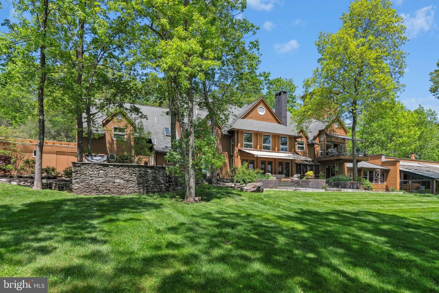 This stunning Pocono Mountains estate incudes an EXQUISITE INDOOR POOL AND FULL SIZE GYM! Indoor amenities abound, making this an ideal year-round retreat centered on 73 acres.
  
Inspired by the beauty and magnitude of its surroundings this remarkable 13,000 SQUARE FOOT residence showcases all the fine materials and craftsmanship of an earlier age coupled with the drama, efficiency and conveniences of modern construction, all finely curated and meticulously maintained. Rare and unusual design elements welcome you to the lodge with an open dining room that will amply accommodate large gatherings and is appointed with Ironwood trees, natural flagstone floor and wall of windows. The voluminous great room was designed with extreme care to blend its strong architectural character and exceptional detailing into a dramatic and comfortable space punctuated by its cathedral ceiling, floor-to-ceiling brick fireplace, African rosewood floors and walls of windows to embrace the sun in the winter and the sun-dappled views in the summer. A thoughtfully planned kitchen, with high-end appliances and amenities to please the most discerning of cooks, opens to a large patio with outdoor kitchen, inviting al fresco dining.  

There should be no need to leave the compound for entertainment. The lodge offers an acoustically engineered MEDIA ROOM, SUNKEN BAR ROOM with fully outfitted marble bar, LIBRARY and a COMMERCIAL GYM. The star of the recreation options is the INDOOR SALTWATER POOL AND SPA complete with desert air system. Here heated flagstone floors and walls of glass doors frame the pool and invite one to swim while the snow flies. Refreshments will be served from the poolside bar and the unique open hearth propane fireplace will enhance the ambiance. Dual bathrooms are conveniently located steps away. 

The second floor primary suite is a sanctuary that draws you through glass doors onto the private balcony to take in the distant mountains with no signs of civilization in view. Here every amenity is elegantly embraced in the adjacent sitting area with fireplace, bedroom area with cathedral ceilings and retractable projection screen. The ensuite bath offers marble steam shower, whirlpool tub and marble vanity. Dual closets and a dressing area with handsome built-ins will amply accommodate your wardrobe. In addition to the primary suite five additional bedrooms, including TWO FIRST FLOOR BEDROOM SUITES, will offer sanctuary to friends and family.  

Comfort is ensured by a commercial whole-property generator, intricate heating and cooling systems and high-tech security system. A historic c.1700s barn was carefully disassembled from its original location and reassembled on the property to provide HEATED GARAGING for 12+ cars and collections. Heated floors, insulated walls and ceilings, remote controlled sliding doors, washer and dryer and separate security system provides enviable workspace. 

The Pocono Mountains with its four seasons of natural beauty, clear lakes and rivers, luxurious resorts and colorful festivals, has been a beloved vacation destination for generations. When you need to leave this extraordinary oasis you will be delighted to know that grocery stores, restaurants, resorts and ski slopes are a hassle-free 15 minutes drive. POCONO SKI RESORTS ARE JUST A SHORT DISTANCE AWAY! New York City is a world away, but can be easily accessed in two hours via Interstate Route 80.