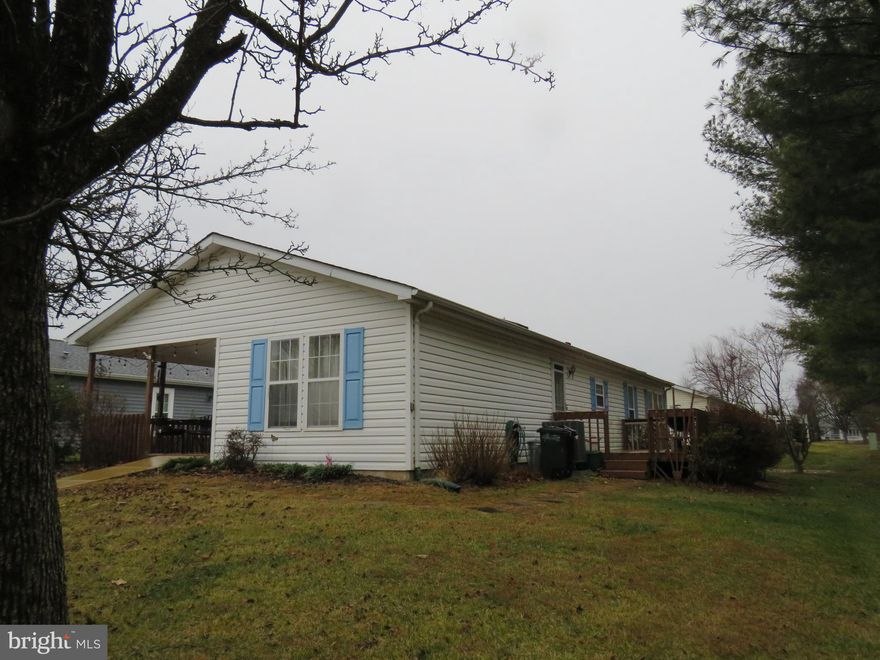Welcome to the active adult community of Villages of Buckingham Springs! This well-maintained Gwynedd model features a ramp leading to a large, covered front porch—perfect for relaxing and enjoying the neighborhood.  Step inside to a spacious formal living room with access to the hallway, Bedroom 2, and a full hall bath located at the front of the home. Just beyond is the laundry room, which includes a door to the side deck and convenient access to the storage shed.  The heart of the home offers an inviting kitchen with breakfast bar, formal dining room, and comfortable family room—ideal for both everyday living and entertaining. Off the dining room, you’ll find the primary bedroom featuring his-and-hers closets and a private en-suite bath complete with a soaking tub, separate shower stall, and a large double vanity.
Engineered wood flooring runs through most of the home. Major updates include a new HVAC system and hot water heater (2019) and a new roof (2017).  This home offers an affordable opportunity to downsize and make it your own—don’t miss it!