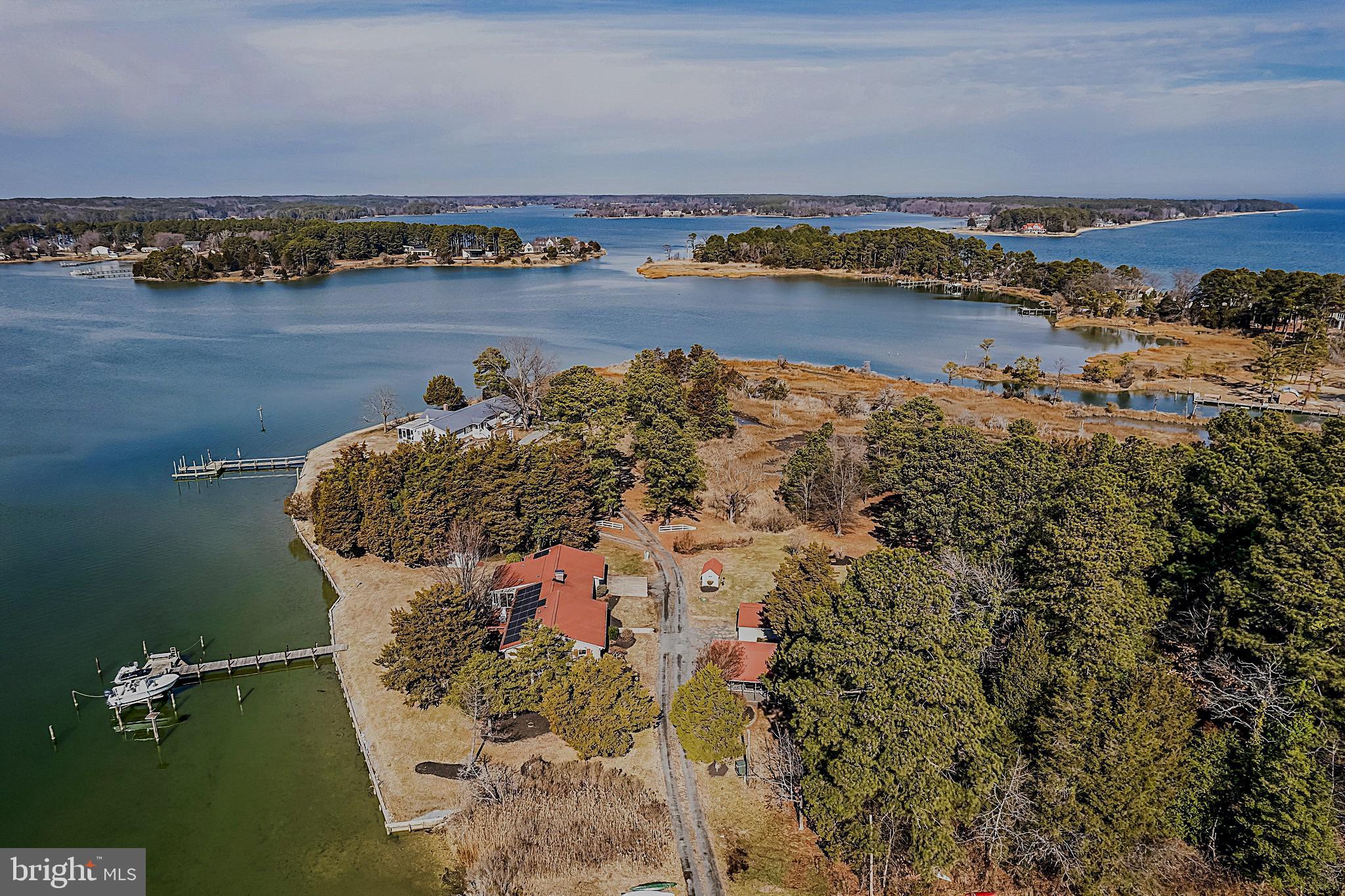 Experience the beauty of Southern Maryland waterfront living with abundant property amenities for ultimate enjoyment of a retreat on Saint Jeromes Creek and the Chesapeake Bay. The water views and setting are exceptional, with an excellent view of the water upon entering the open floor plan of the home, as well as the primary bedroom suite accessing the adjoining hot tub with pergola overlooking the water, and the large four seasons waterside room providing flexibility. The 4.36 acre property features expansive frontage on the creek with a pier offering an 8000 lb boat lift, jet ski lift, electric, water, and lighting. An additional recently updated cottage can be used as guest or extended family space, as well as for rental income. There is great vehicle and boat storage in the attached 2 car garage and additional 2 car carport, as well as three storage sheds. Also offered is a large workshop with electric. Improvements to the property are a new septic system, new HVAC 2025, roof replacement in 2015, solar panels in 2016 and a conditioned crawl space with water conditioning system. In addition to the water activities, there are many other great things to do in the area – restaurants, historical sites, parks, charming Solomons and Leonardtown, nearby Virginia and Maryland wineries, and more. This very special getaway is convenient to the metro area and presents many opportunities having the essentials for a variety of flexible uses.