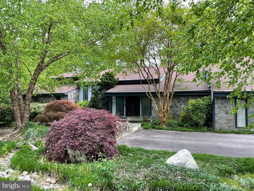 Do you think outside the box?  Then this home is for you!  Interesting and innovative, fantastic custom built mid-century modern, stone and wood contemporary with a California vibe awaiting your creativity.   Exceptional vintage tiles, soaring, 24' redwood ceilings with skylights and indirect lighting,  antique Church doors, a Portuguese balustrade from the 1700/1800s--so many unique details.  Big open floor plan with a main level great room/dining room; renovated kitchen; private main level Primary Suite with his and her baths; separate kids/guest/family wing along with private entrance au pair/in-law apartment.   Attached, oversized two car garage PLUS a separate, stand-alone three car garage/potential studio.  Unbelievable location on private, quiet street w/gated entrance, fully fenced 1.11 wooded acres close to Potomac Village with public water and sewer.  Extraordinary specimen plantings/landscaping with flagstone hardscaping. A new and different, more casual lifestyle awaits you...embrace it today!